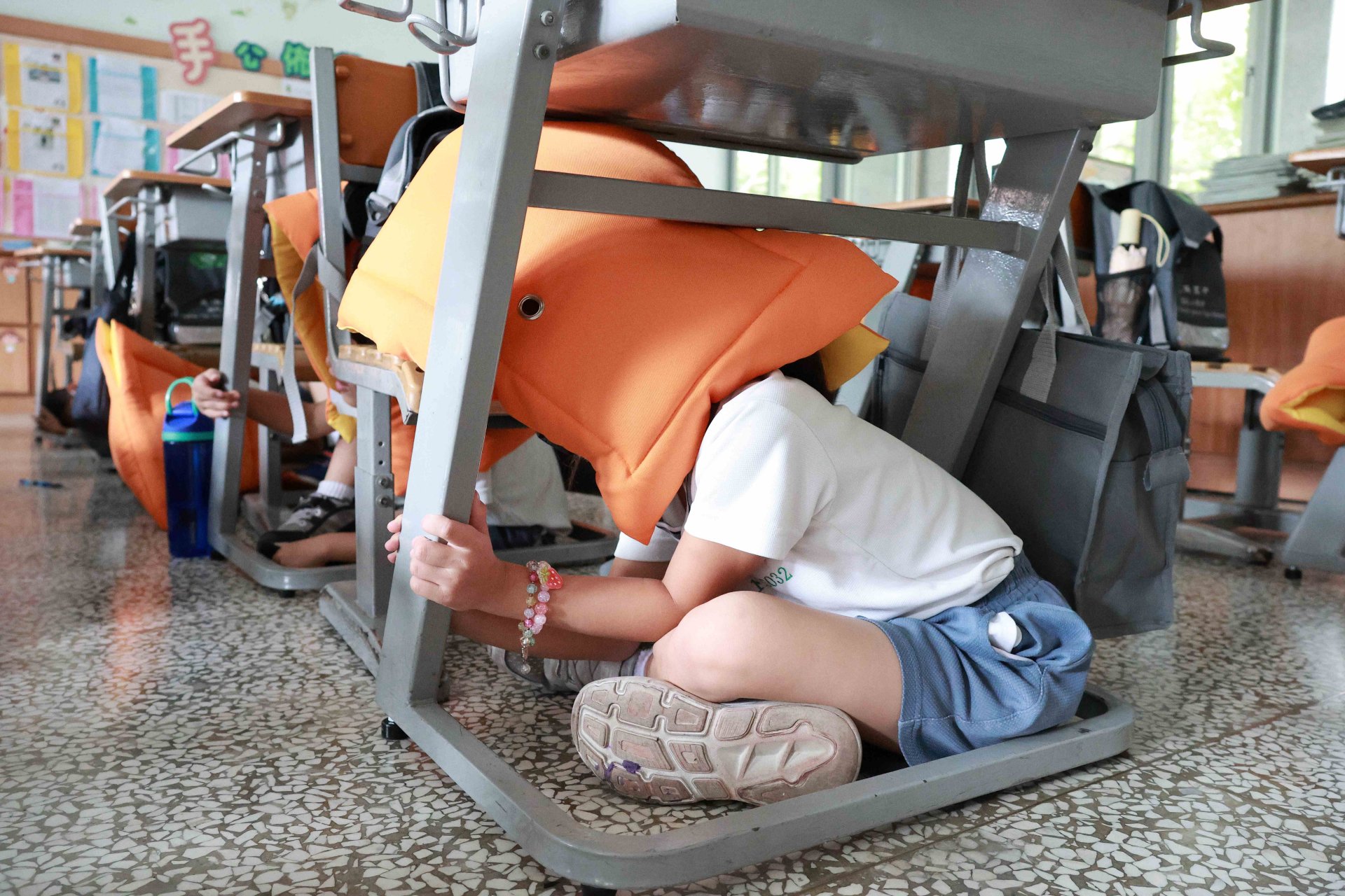 臺南慈小的孩子們在老師引導下，依序進行「趴下、掩護、穩住」的保命三要領。