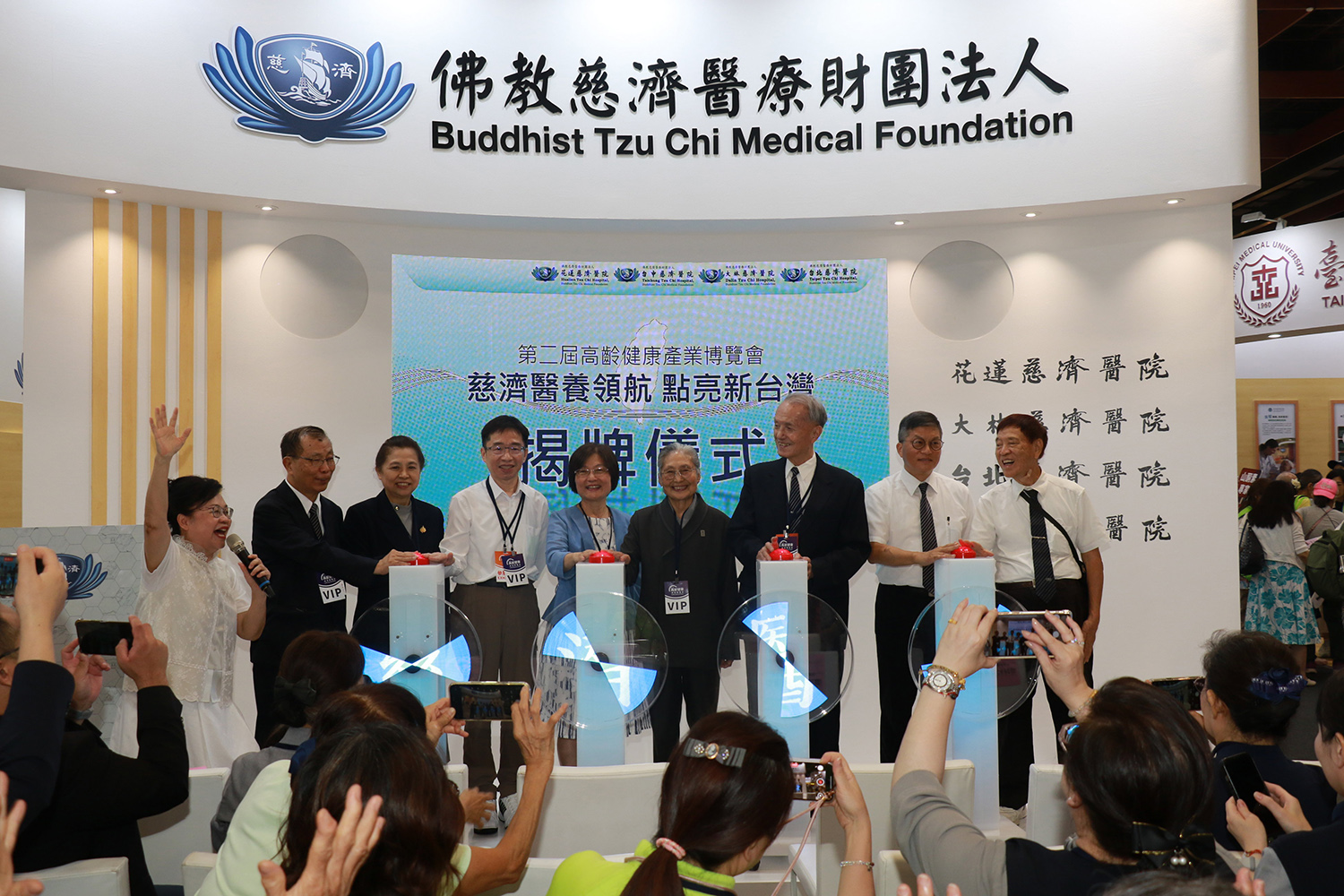 衛福部官員親臨慈濟醫療體系展區參加揭牌儀式，與慈濟慈善、醫療、長照主管共同點亮「慈濟醫養新臺灣」。 