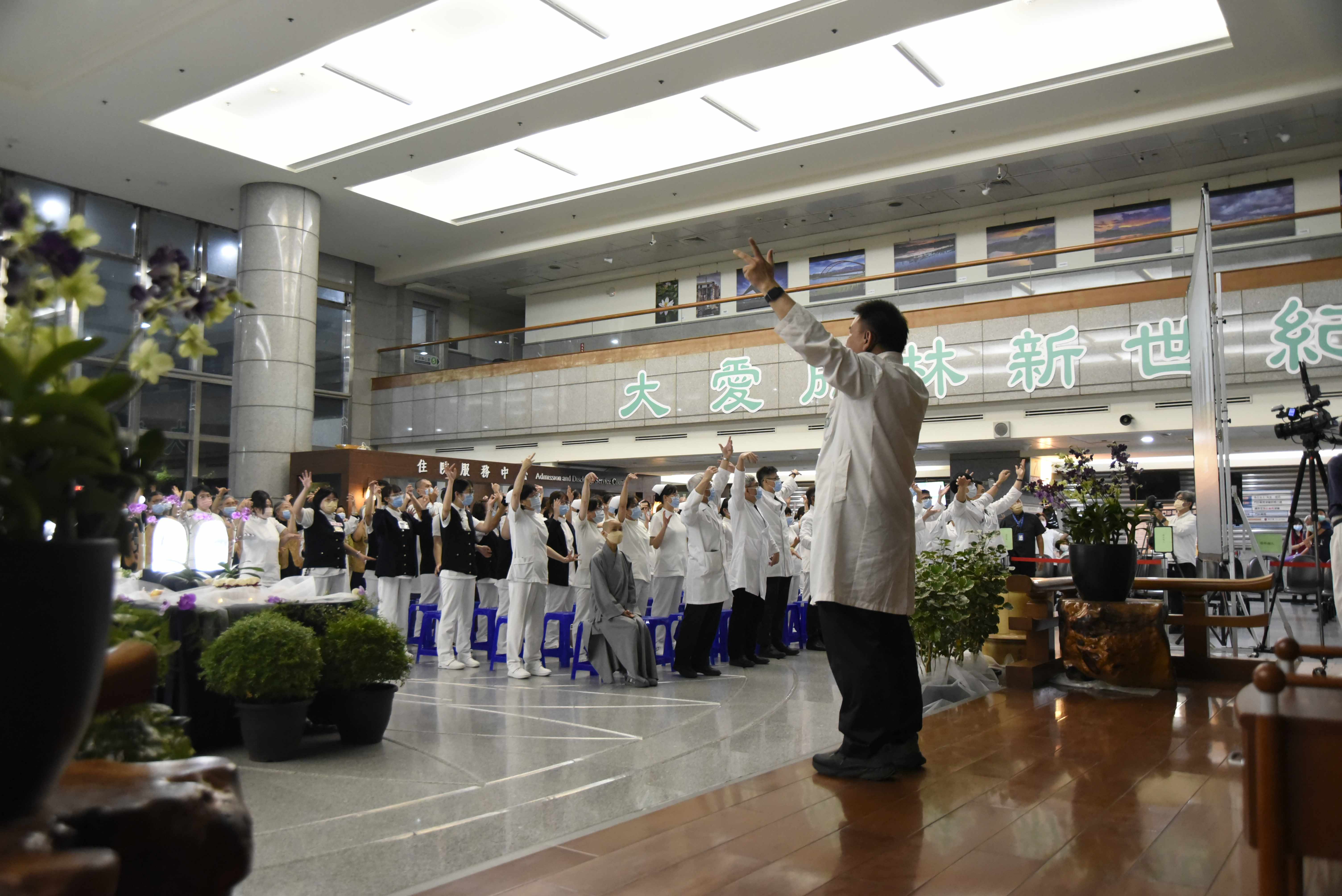 為了讓同仁在忙碌工作之餘，也能放鬆身心、提升健康，中醫部主任葉明憲帶領住院醫師現場教導「勇健梵唄」無量義經法髓頌健身操