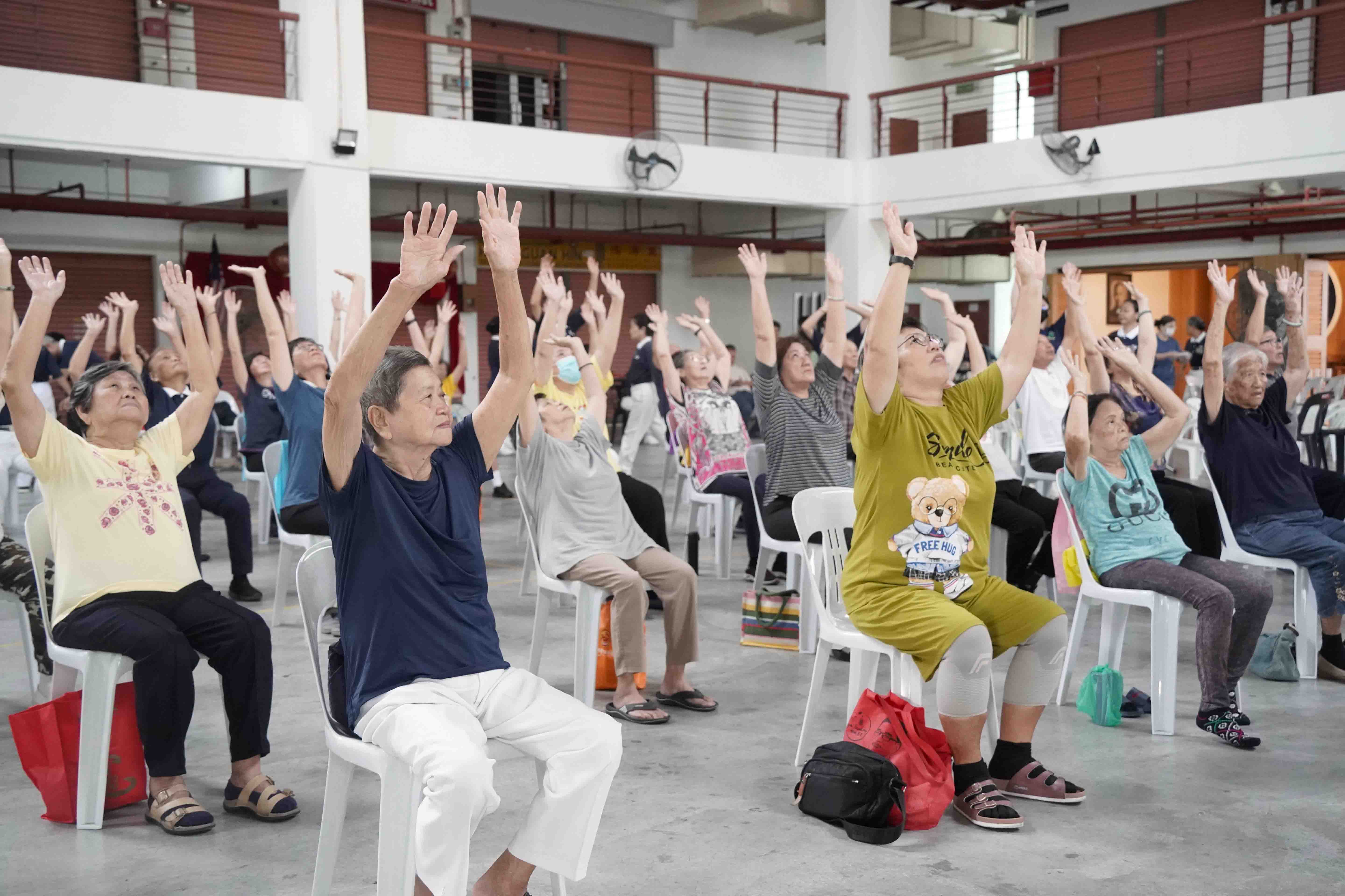 慈大與馬來西亞志工,於服務尾聲共同合作帶領長者們透過物治操,達到活動關節的目的。