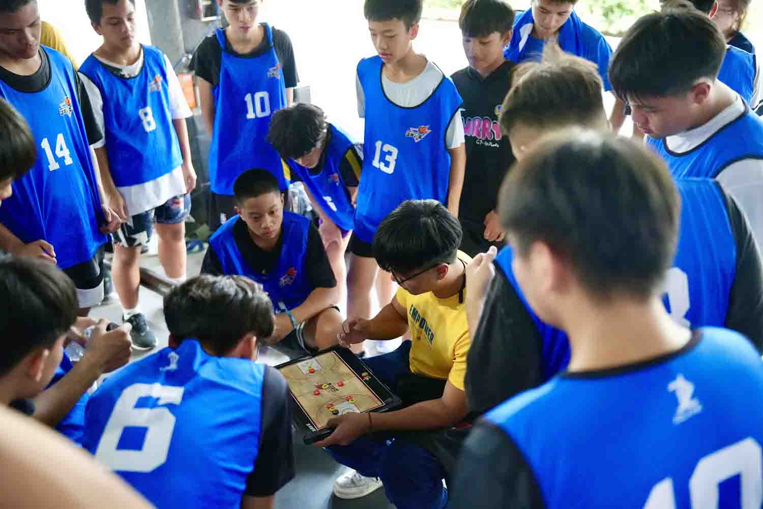 球員們聚在教練身旁，專注聆聽每一個攻防戰術指導。(台灣世界展望會提供）