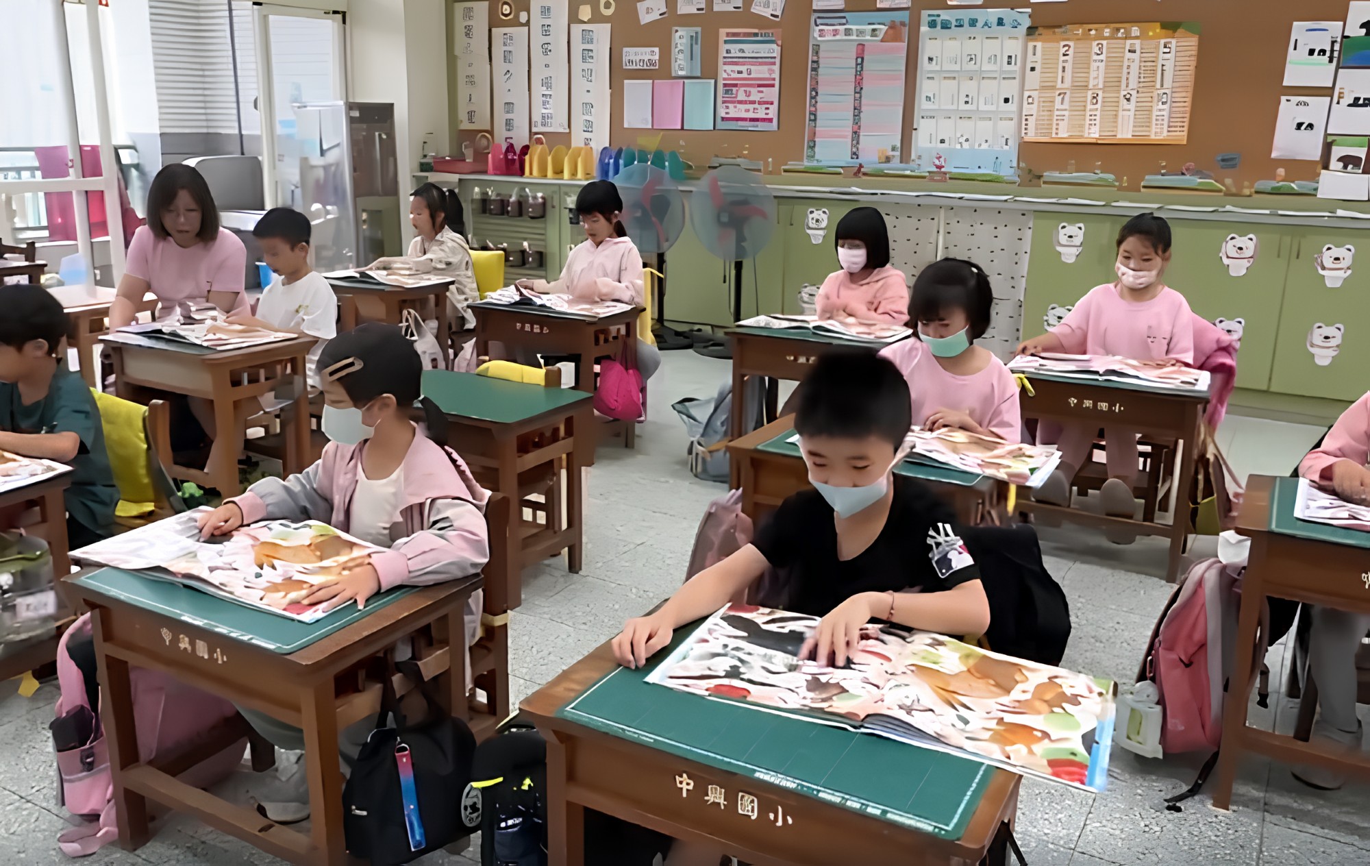 宜蘭縣中興國小校長入班陪伴學童英文閱讀,以身教支持與帶動英文閱讀。