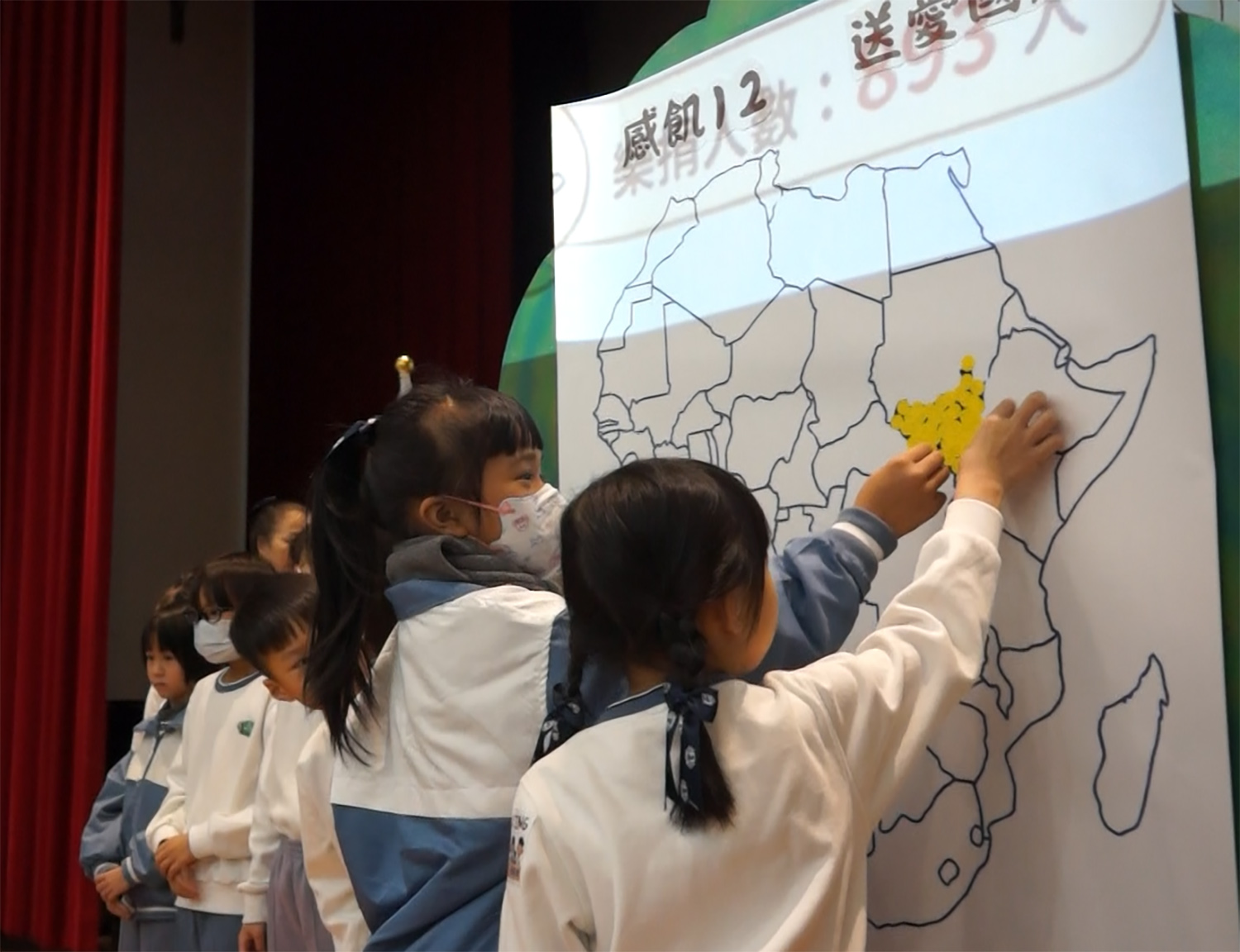 校長及師生以象徵愛心的螢光貼紙，用愛點亮南蘇丹，傳遞希望與。