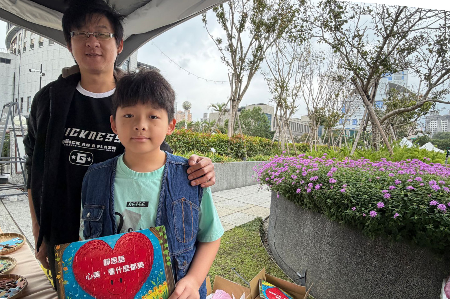 來到攤位，兒子選了「心美，看什麼都美」的靜思語拼圖，紅色的大愛心，是愛的提醒。父子的「心美」約定，要把靜思語的智慧用在生活裏。