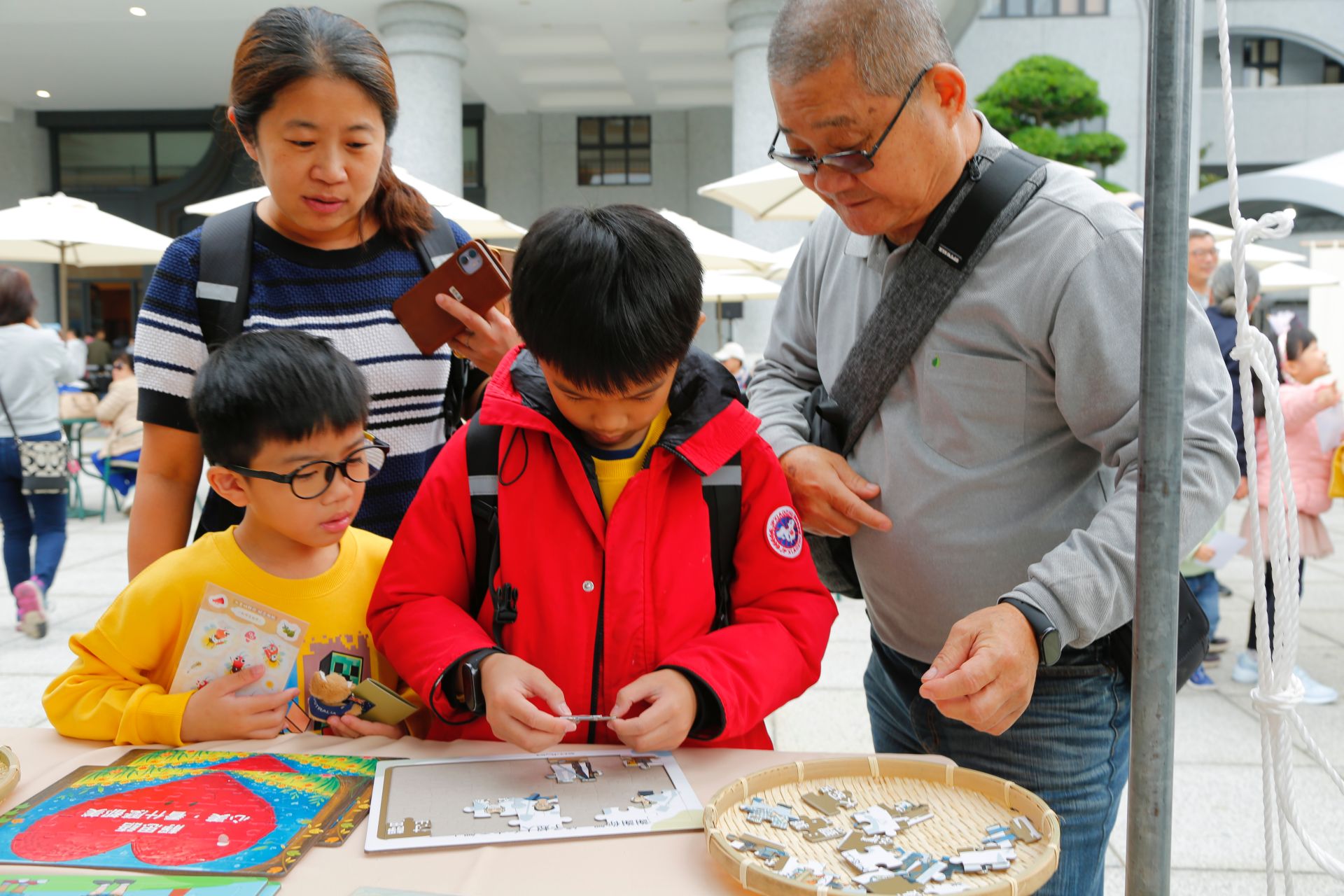 一幅「鏟子超人」拼圖吸引了吳Ｏ恩(前排中)的目光。他仔細觀察，將零散的拼圖，逐步拼湊成圖。
