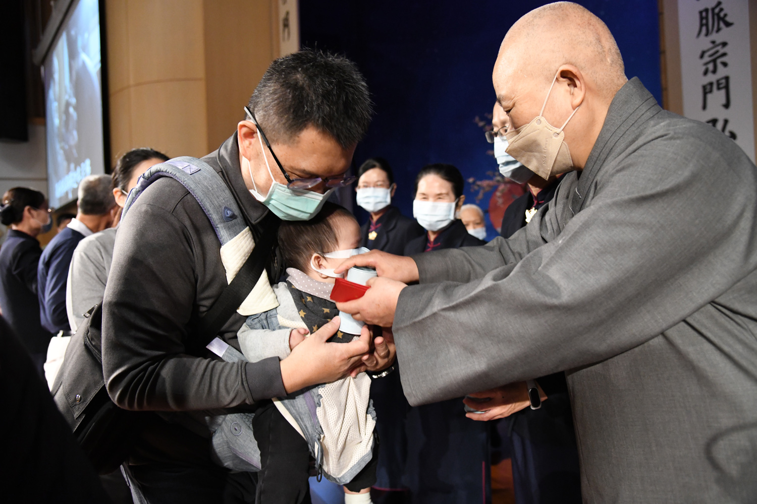 小朋友在德讅師父的祝福下,領到一個小福慧竹筒。