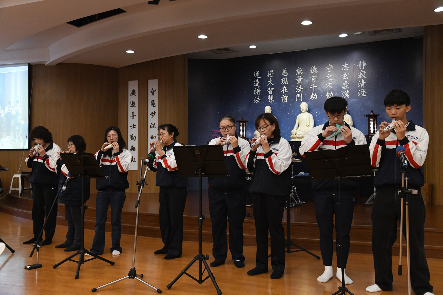 在志工吳玲華(左一)邀請下,「大莊香酥臭豆腐」的黃崧烈(左二)首次走入新竹靜思堂參加歲末祝福,與會眾分享他與慈濟的因緣。