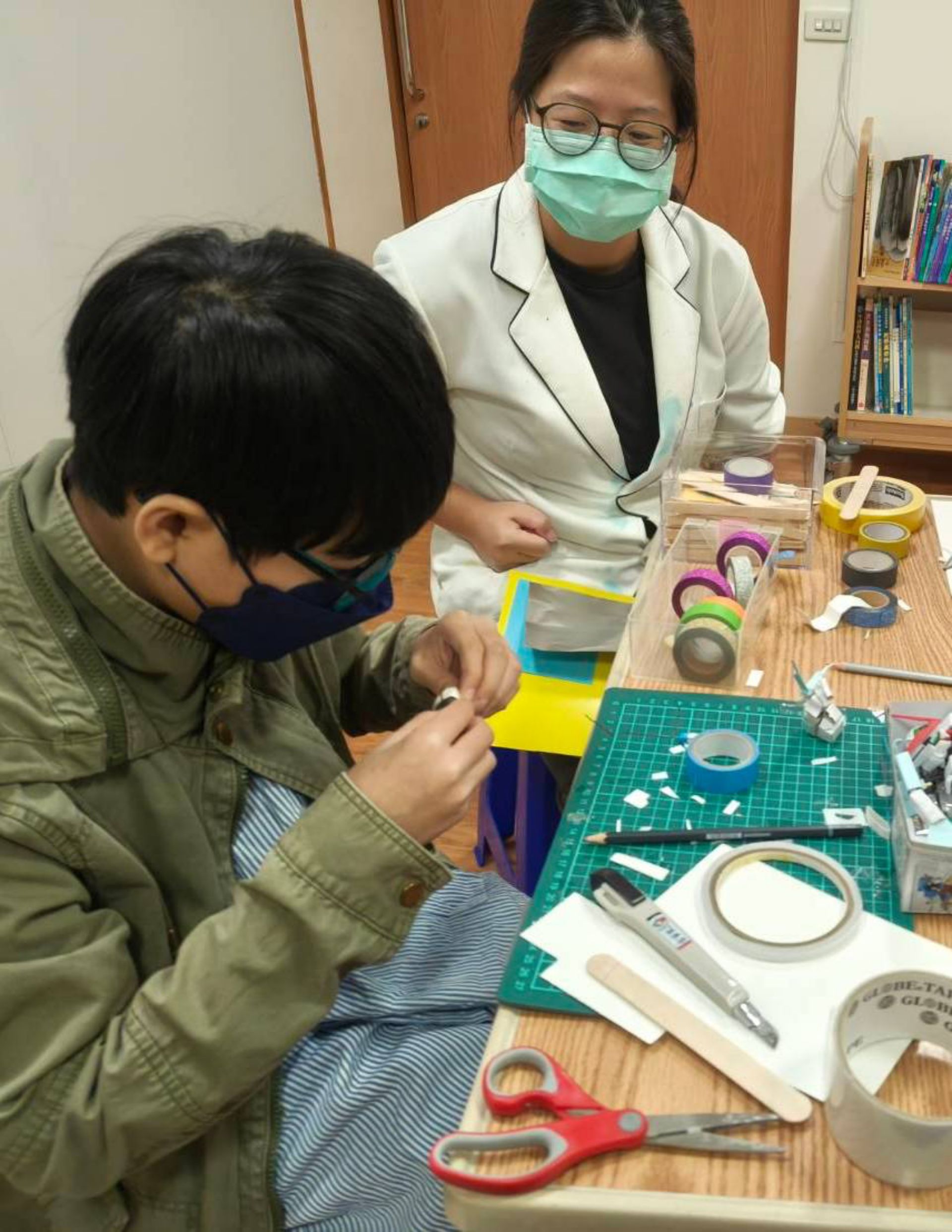 藝術治療師與音樂治療師到病房，藉由音樂與手作遊戲，減輕樂樂住院不安的情緒。