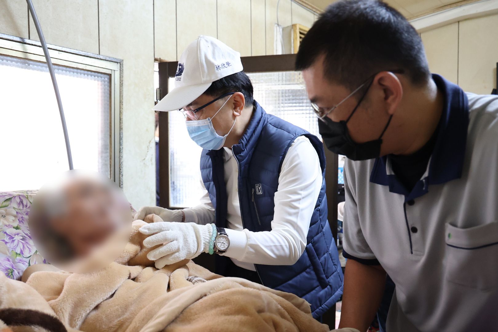 林欣榮院長(中)關懷中風病人吳先生(左)，右為花蓮慈院照顧服務員。