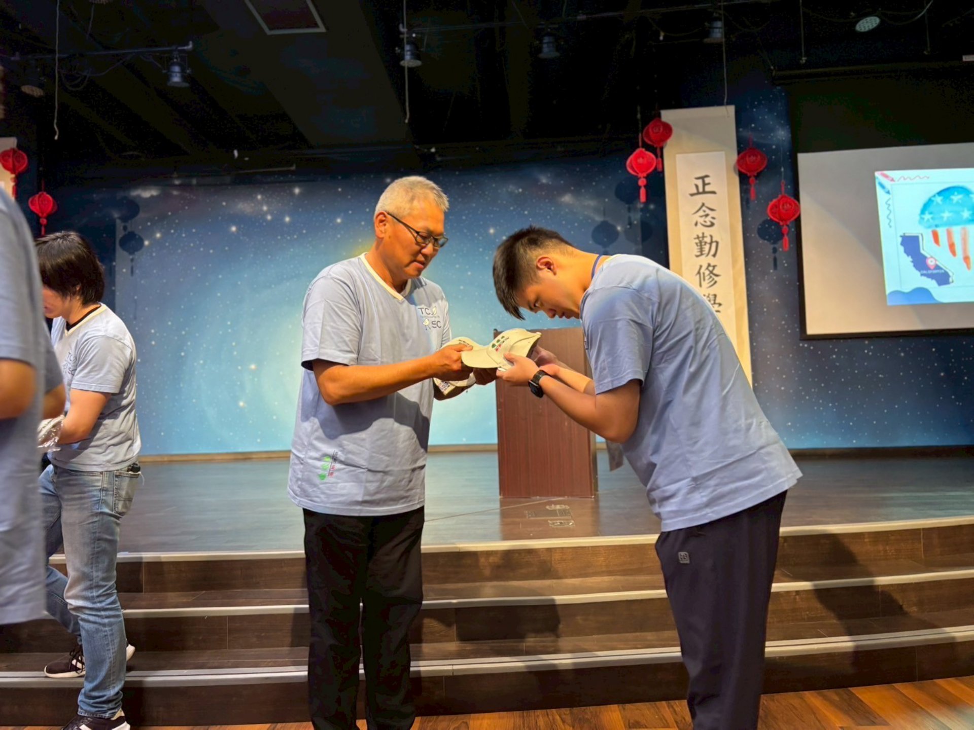 慈濟美國教育基金會副執行長杜賓師伯親手為每位學員戴上營隊帽，象徵著嶄新旅程的啟動