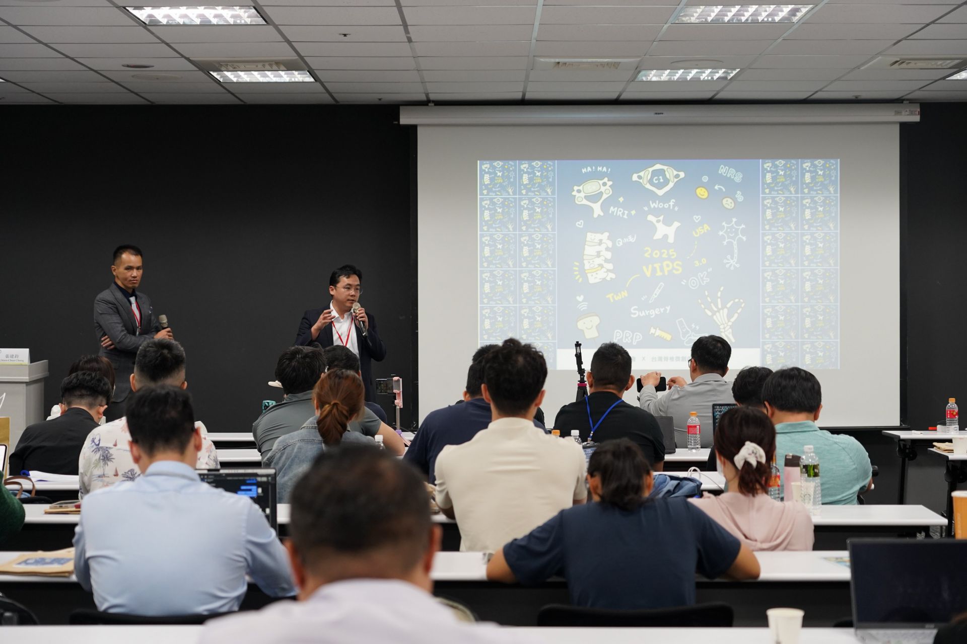 台中慈濟醫院微創脊椎關節中心主任張建鈞（右立）與疼痛治療科主任唐宗詠（左立），分別從微創外科與疼痛介入觀點解析術後疼痛處理，體現跨科協作實力。