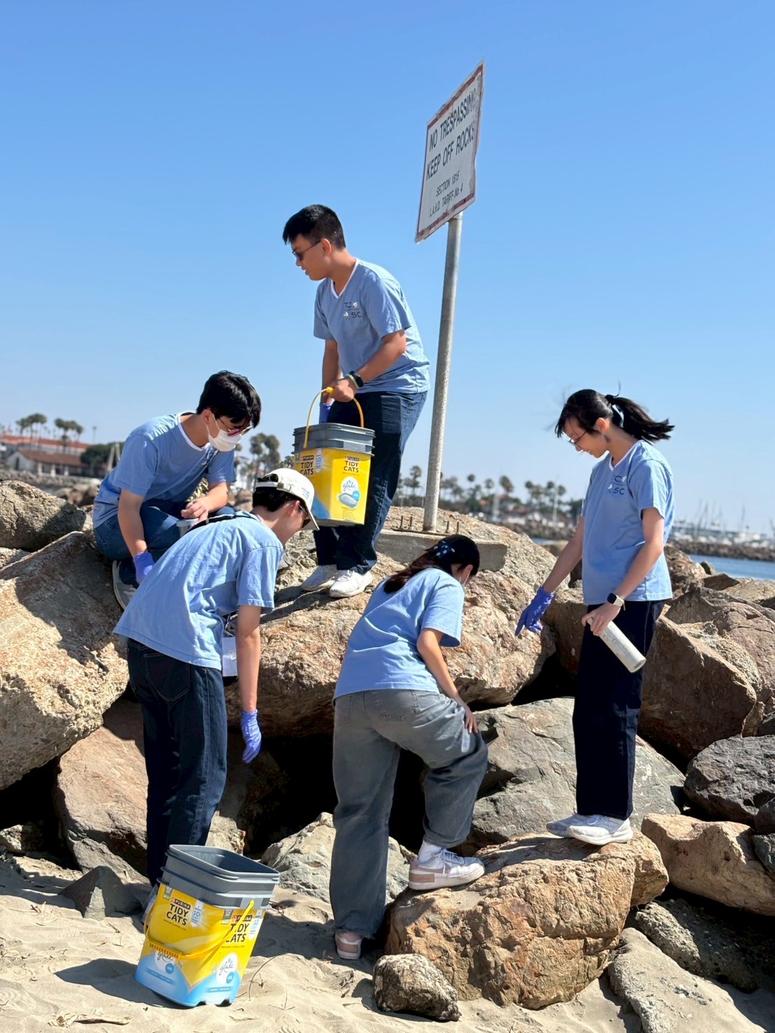 同學們身體力行投入淨灘志工活動，國慶日後海灘遺留不少人造垃圾，大家細心撿拾，連岩石堆縫隙中的廢棄物也不放過。