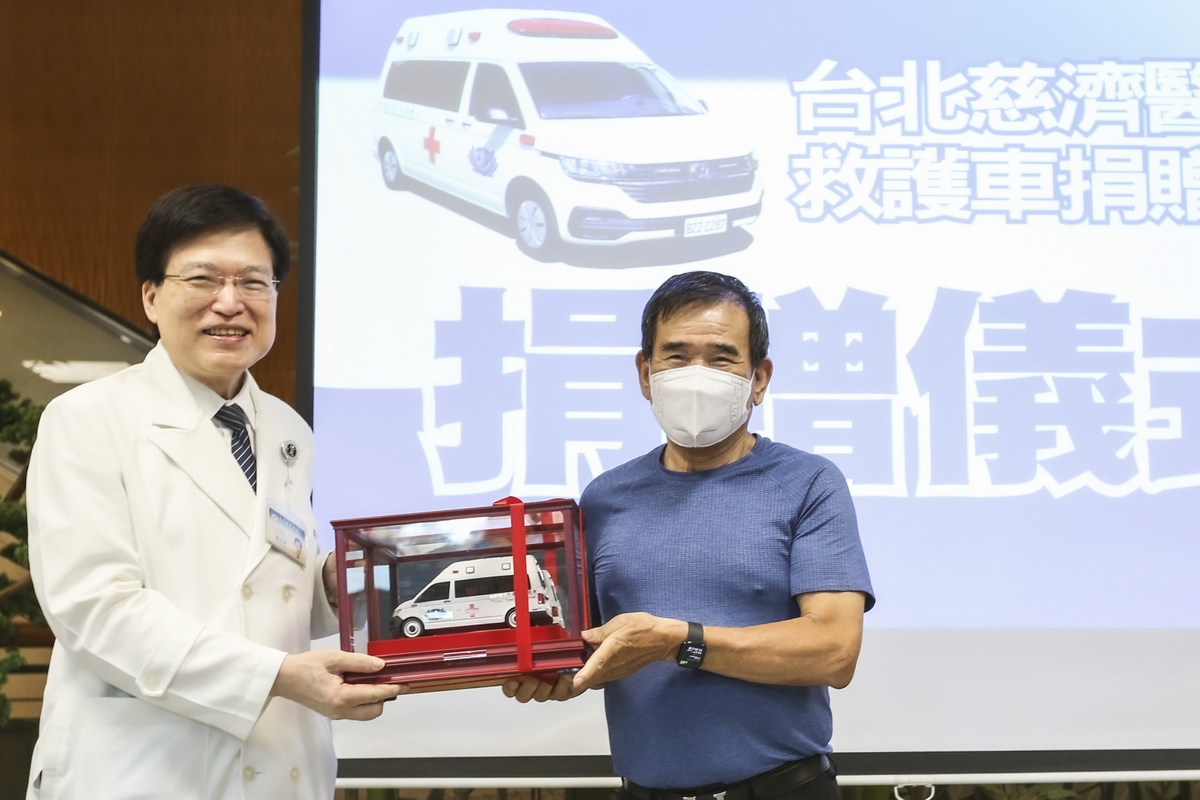 郭來福先生將救護車模型交付到趙有誠院長手上。