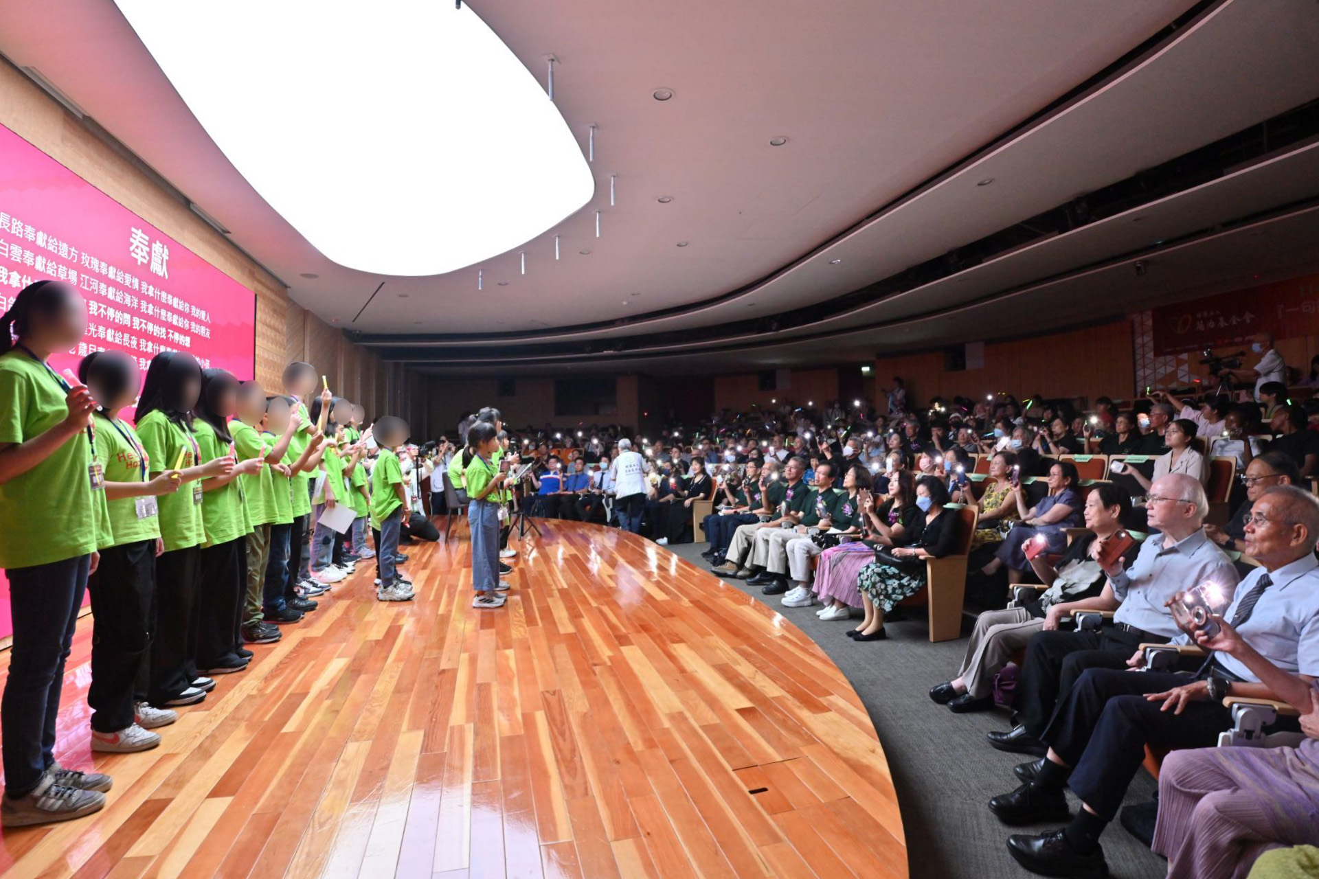 社團法人南投縣以琳社會福利關懷協會 護幼苗成大樹弱勢兒少課輔班學生與全場嘉賓合唱歌曲「奉獻」，點燃滿場燈海，代表愛的傳遞，也象徵著支持與陪伴的力量。