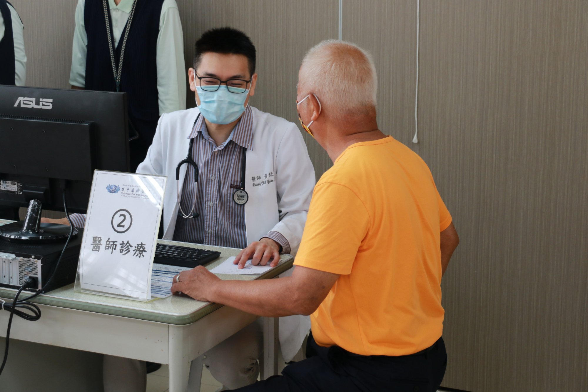 (左)台中慈濟醫院家庭醫學科黃致遠醫師，為年長居民細心看診。