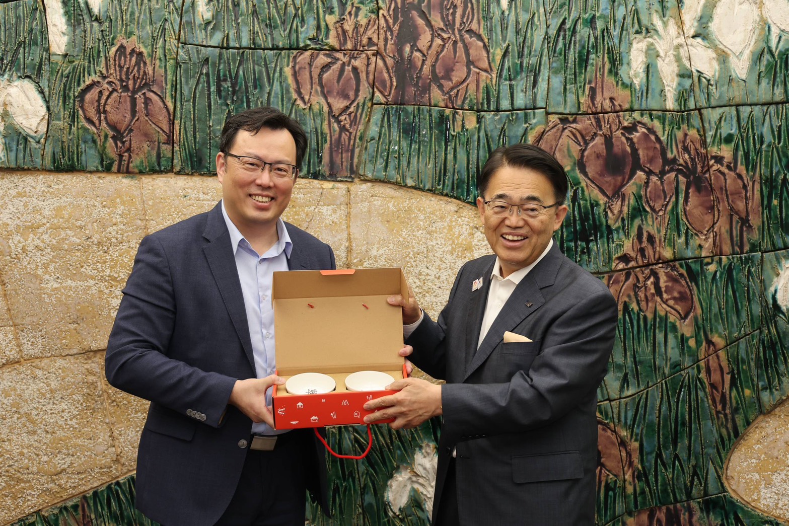 體育署鄭世忠署長(左)率員考察名古屋亞運後勤支援環境，並拜會愛知縣大村秀章知事（右），雙方互贈禮品，以示友好。
