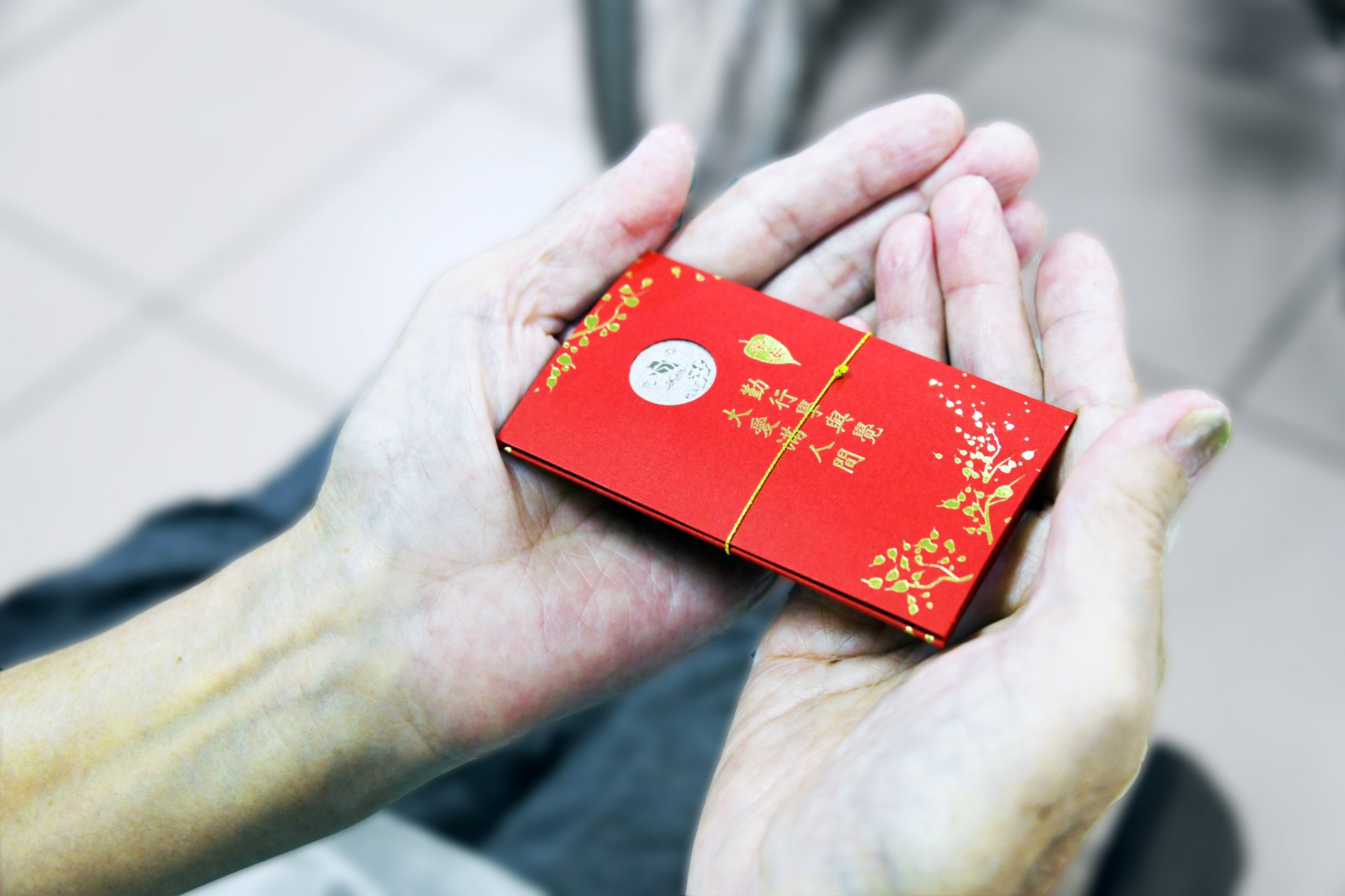 鄭主任特別向人文室申請了證嚴上人對大眾的祝福─「福慧紅包」。他親手將這些象徵平安與祝福的紅包，送到長者們的手中。