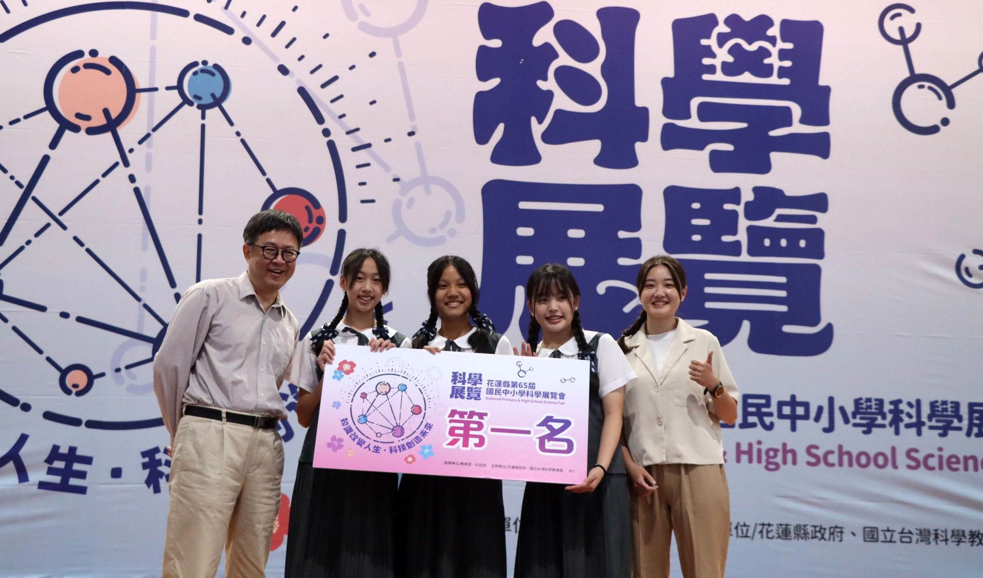 三位學生與指導教師游逸柔一同登台領獎