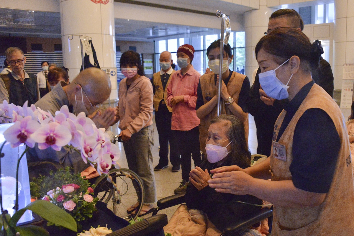 因雨勢較大，前來現場的住院大德皆改以在醫院大廳進行浴佛，圖為81歲的兵李奶奶。