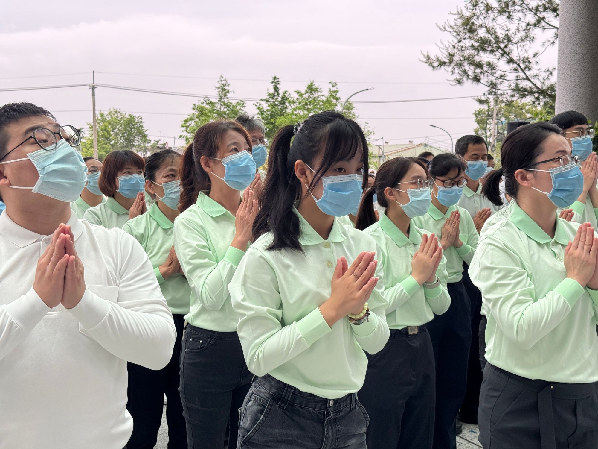 病人家屬陳小姐（中排二）感念母親住院期間醫護人員的細心照護，偕家人參與浴佛，為母親祈福。
