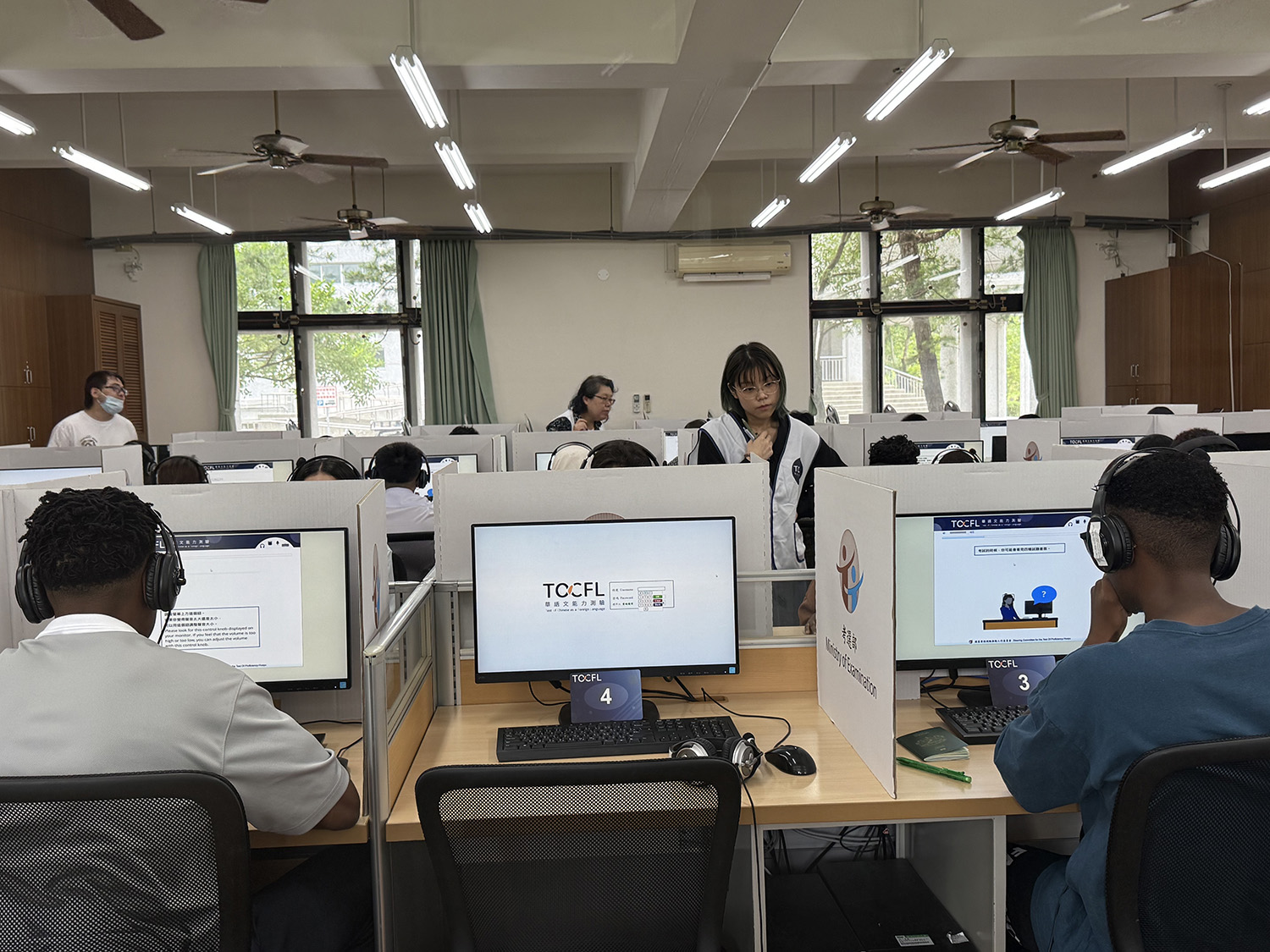 監考老師協助學生解決軟體問題。