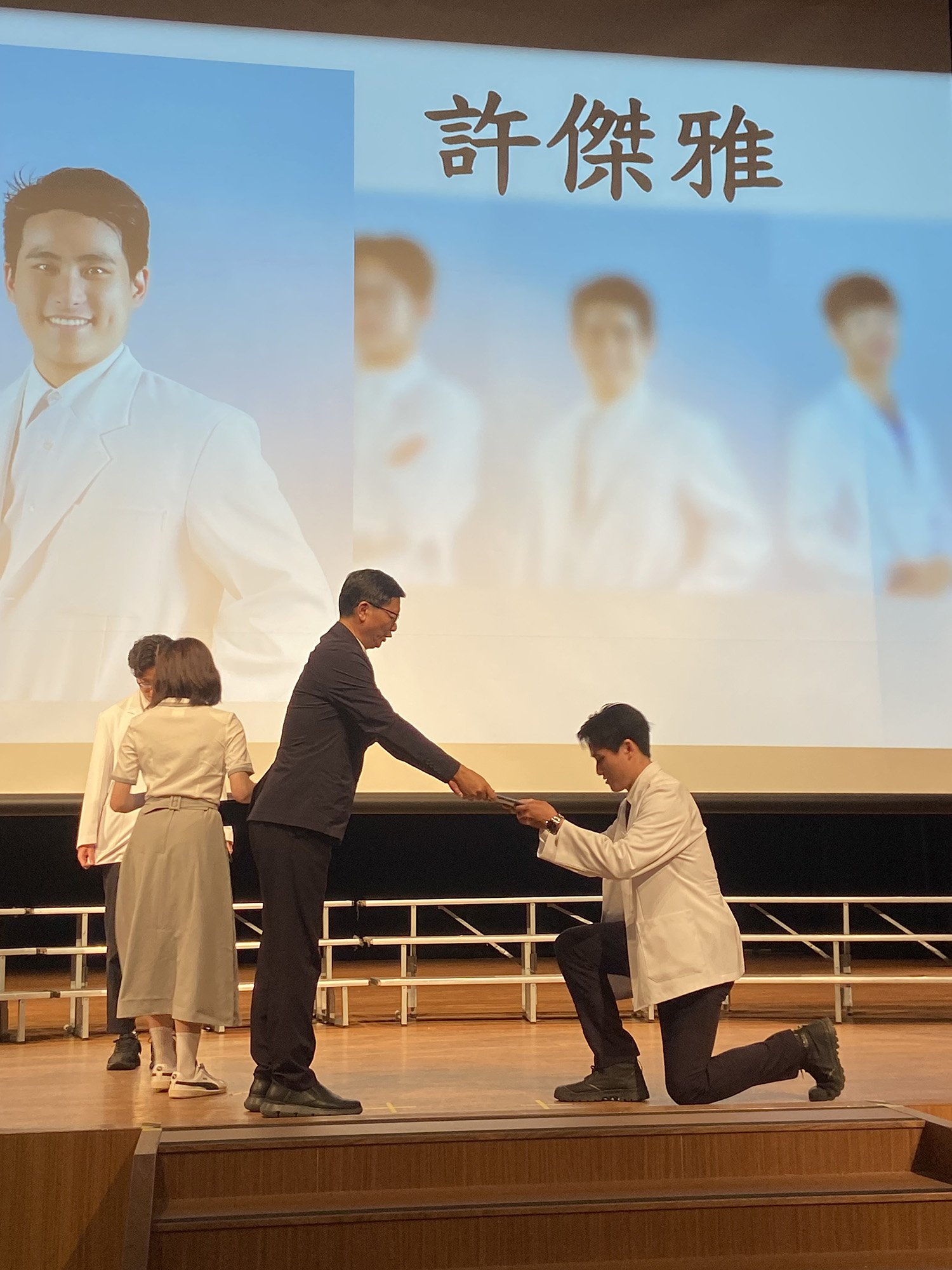 由師長親自為學生穿上白袍，授予名牌和證書。