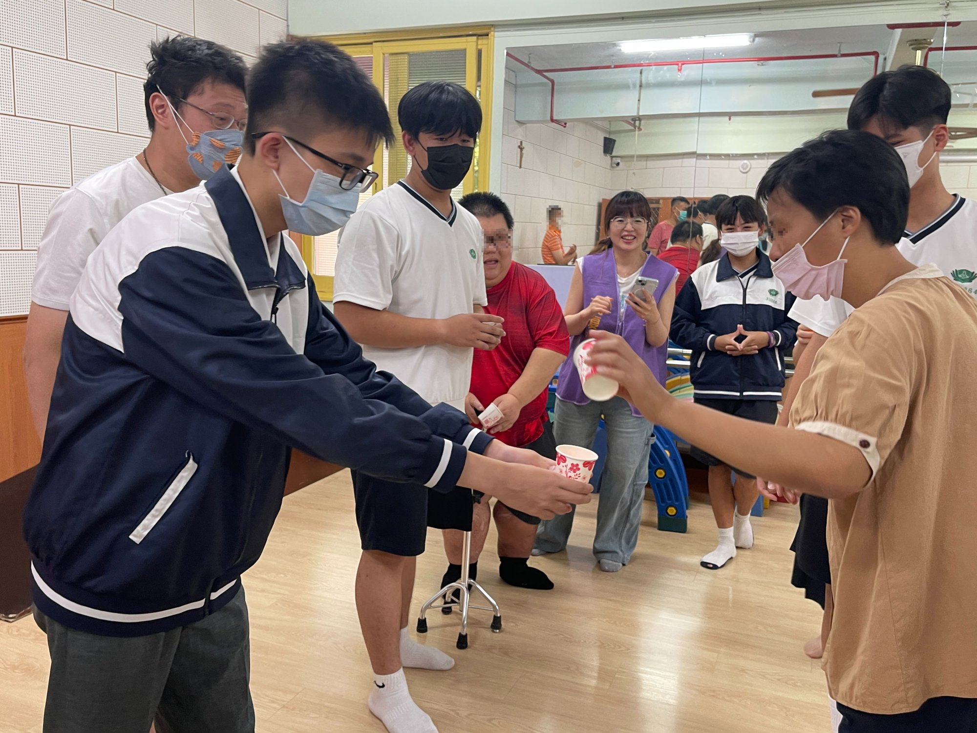 以相互尊重的的心，雙手承接院生傳遞的乒乓球。