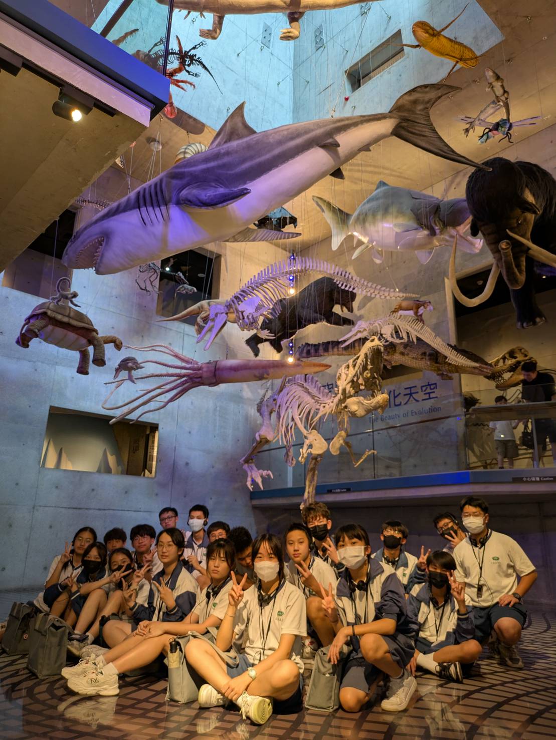 班級團拍背景選在生命演化館絢爛天空下，滿布各式海洋生物模型，壯觀場景襯托畢業氛圍，浪漫又難忘。