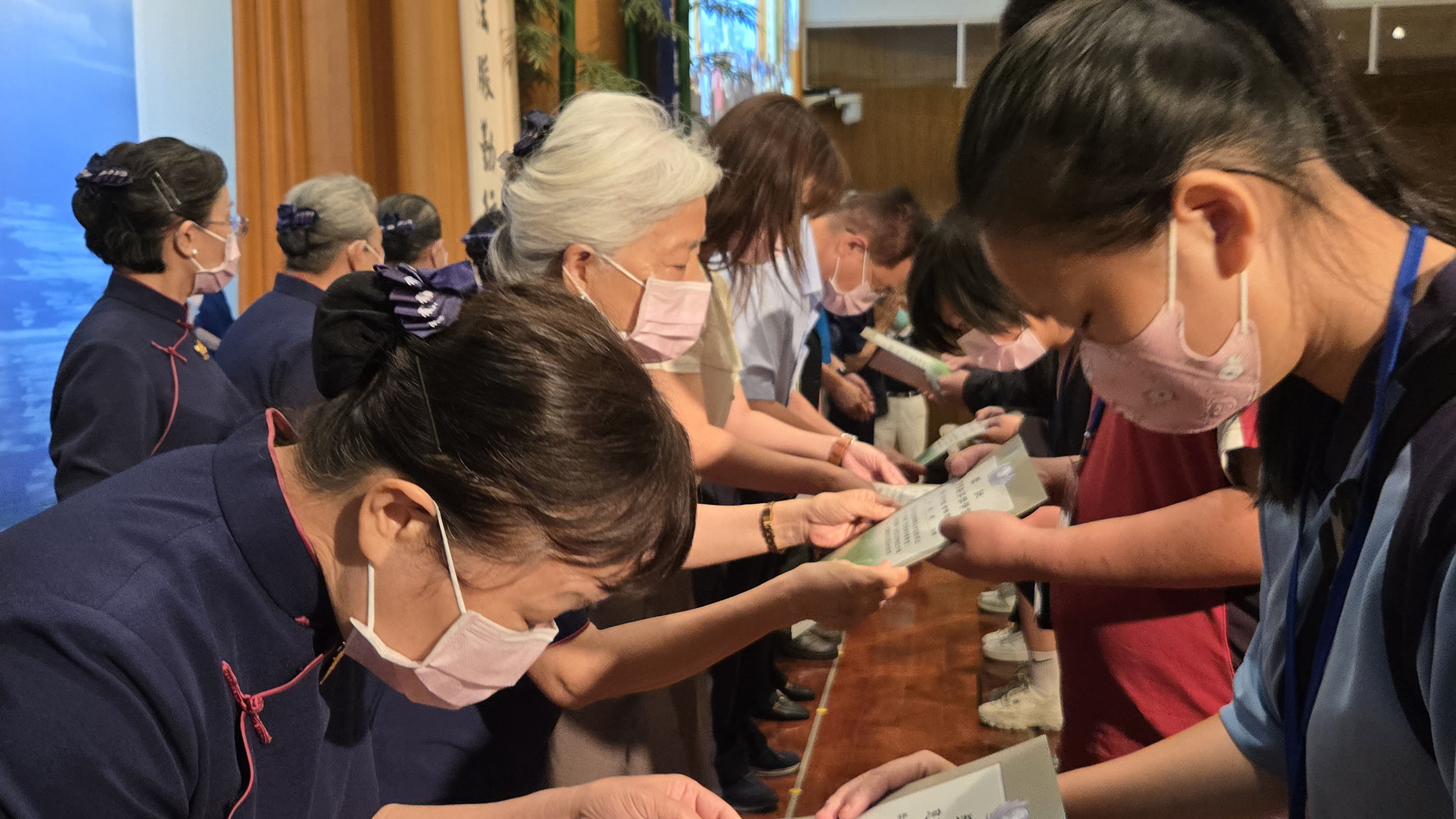 慈濟師兄姊頒獎給學子獎狀鼓勵。