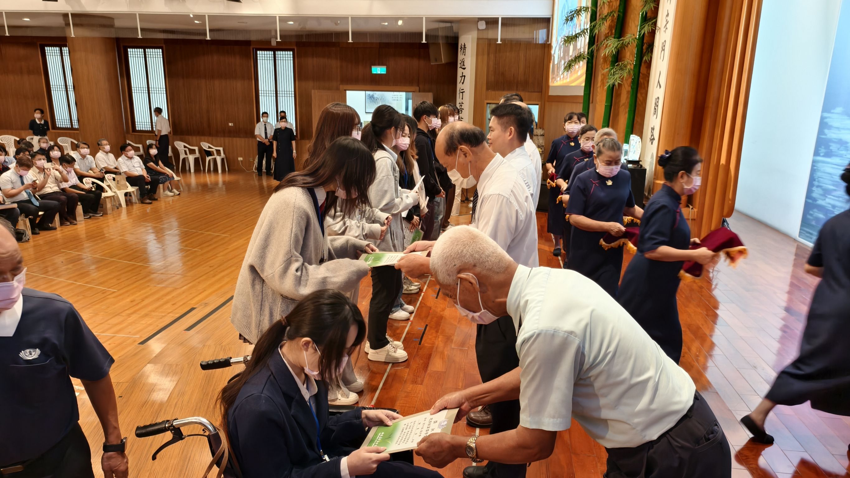 慈濟師兄姊頒獎給學子獎狀鼓勵。