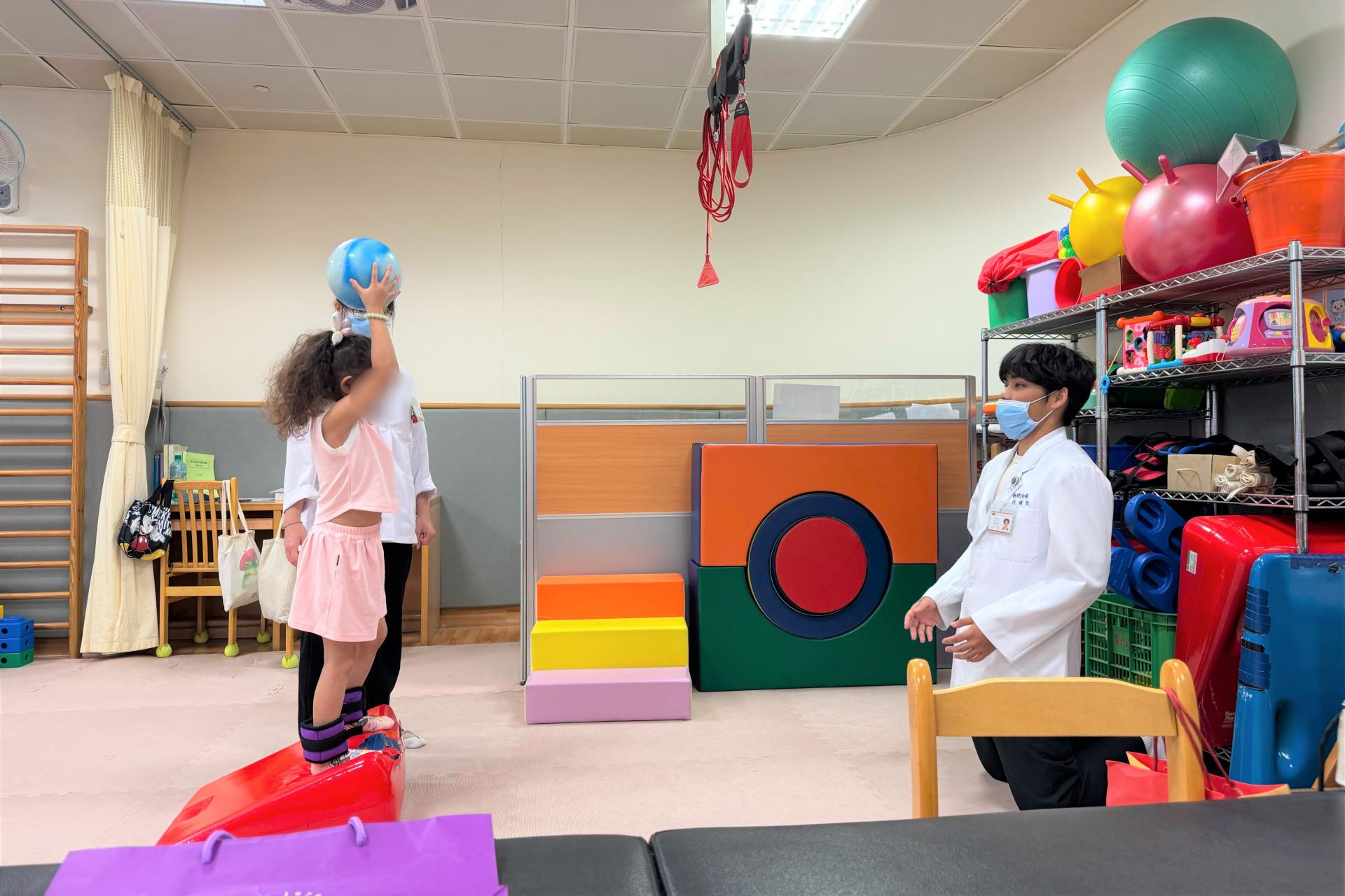治療師陪著瑤瑤做物理治療。