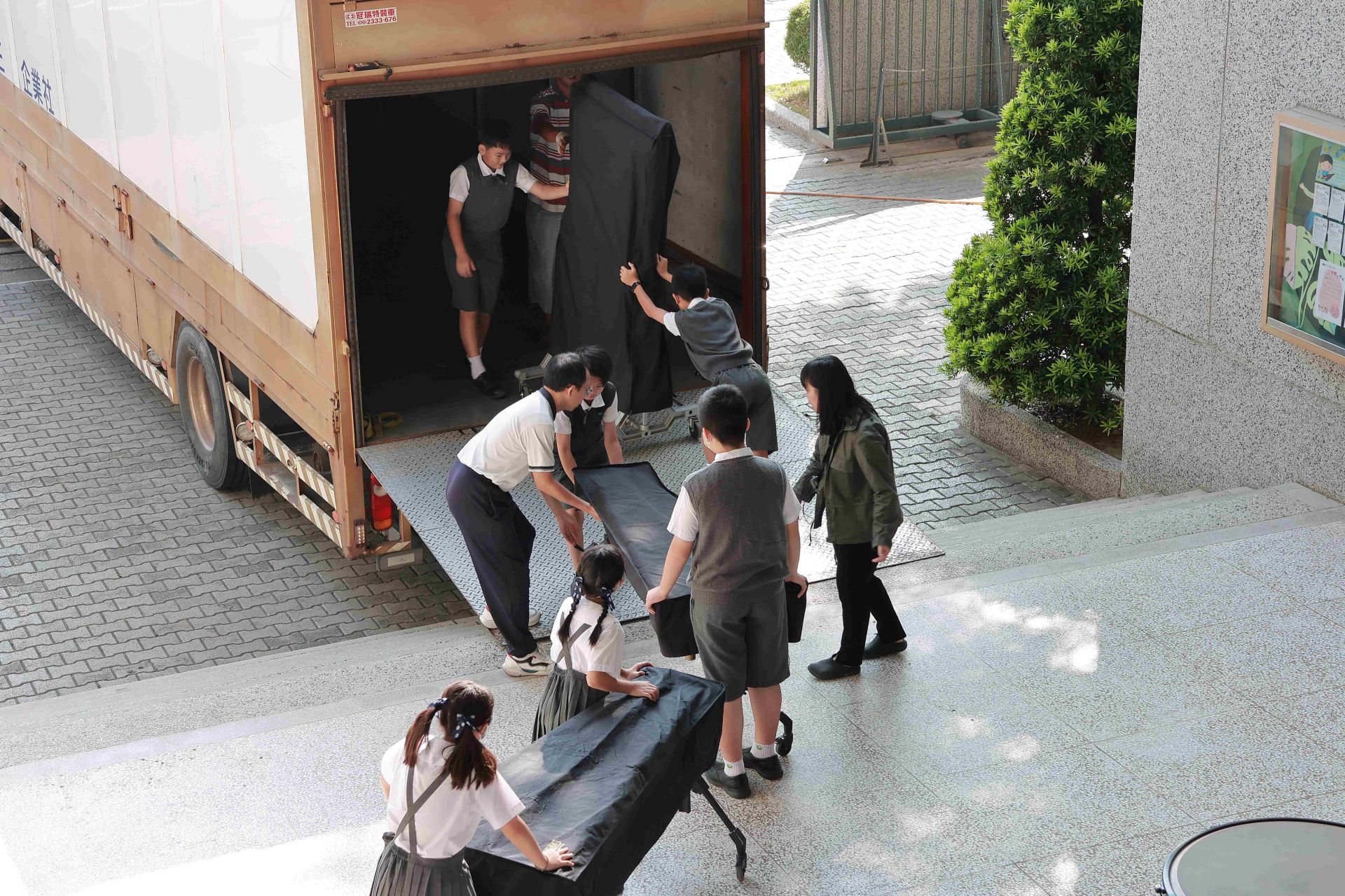 老師與學生合力搬運樂器上車展現慈小師生間最真摯的團隊情誼與彼此扶持的力量。