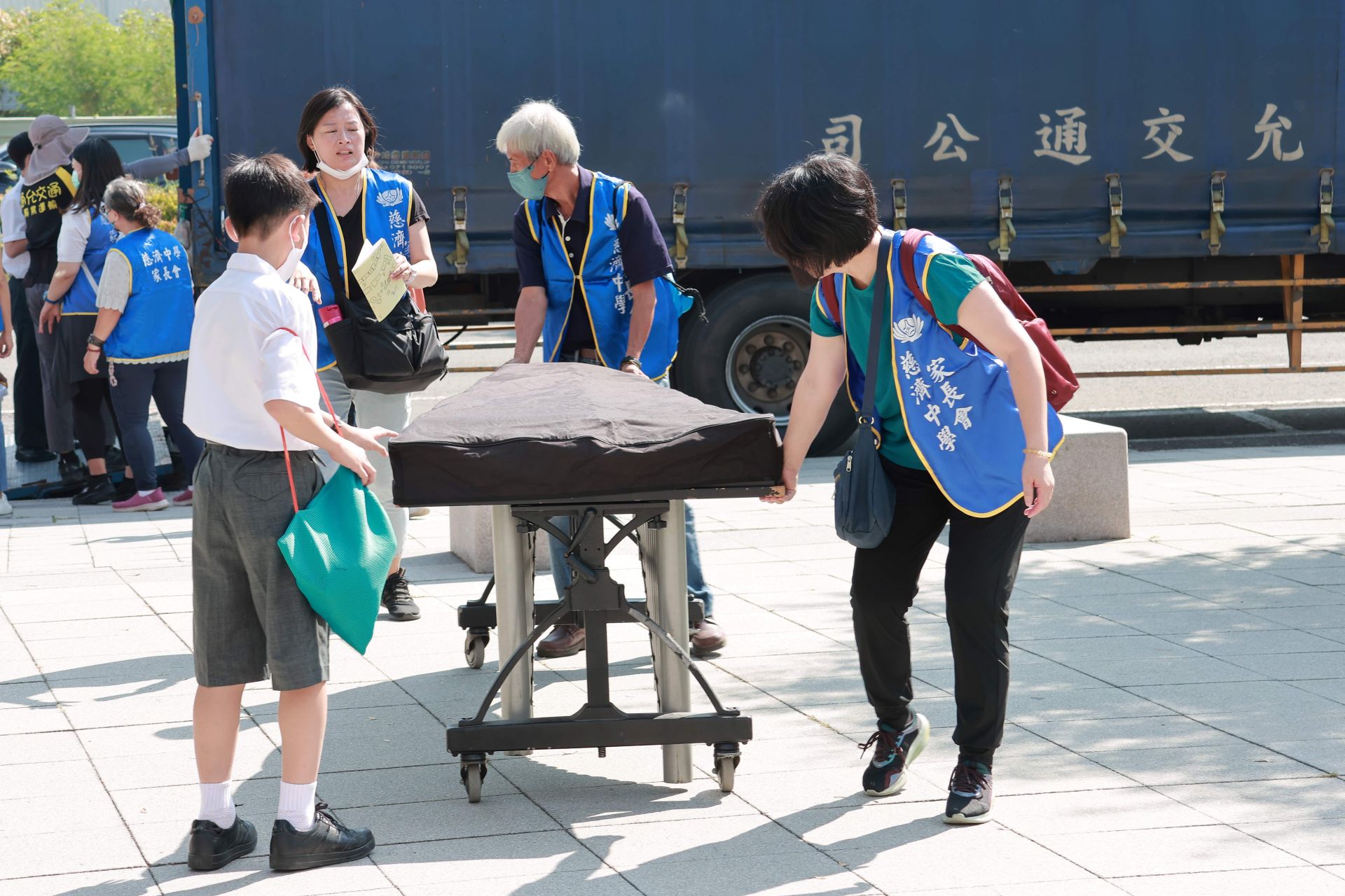 家長志工與孩子們合力搬運樂器，展現慈小親師生一條心的團隊精神。