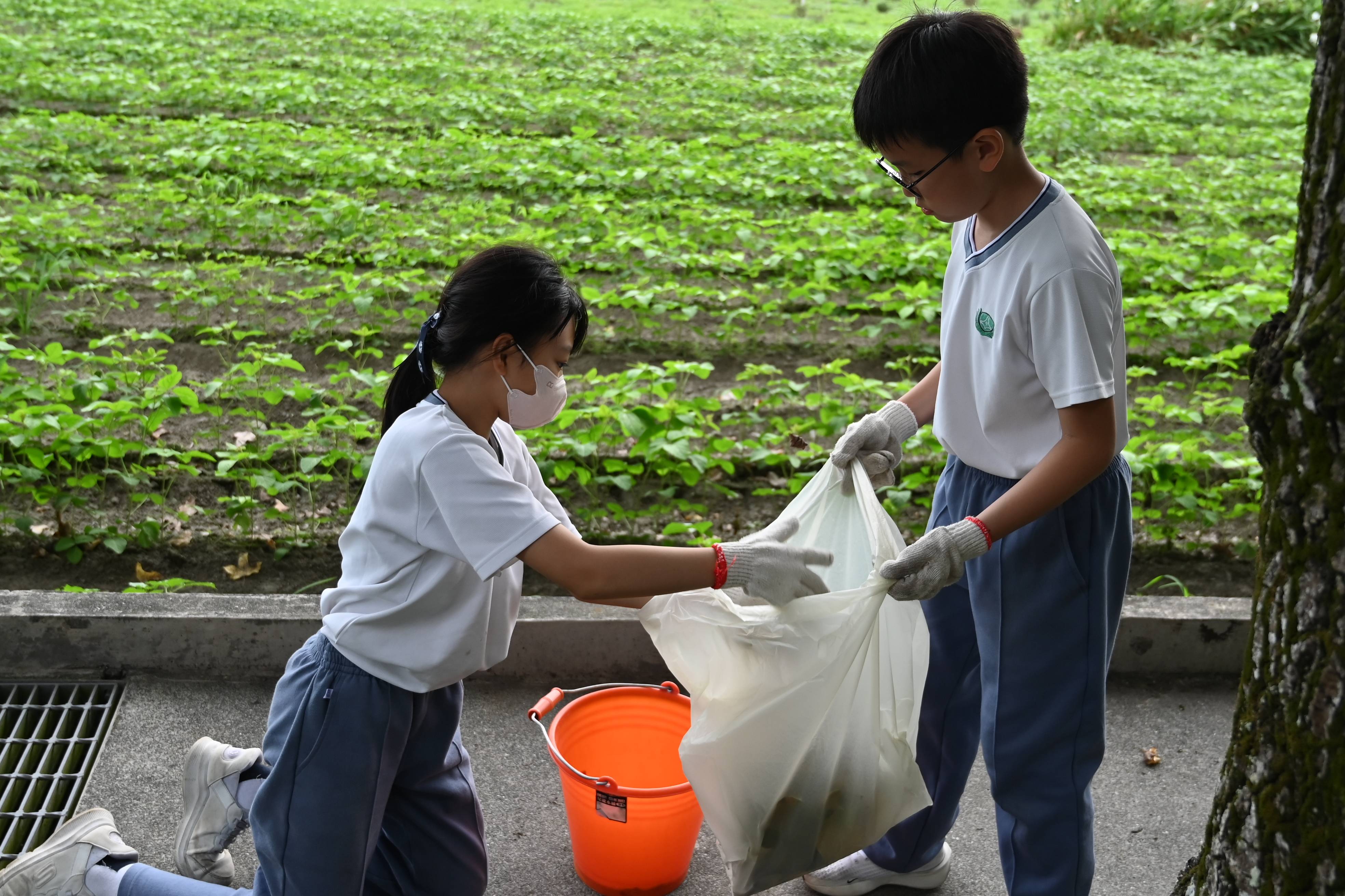 回到心靈故鄉-靜思精舍，孩子們同心協力，將地上落葉撿起。