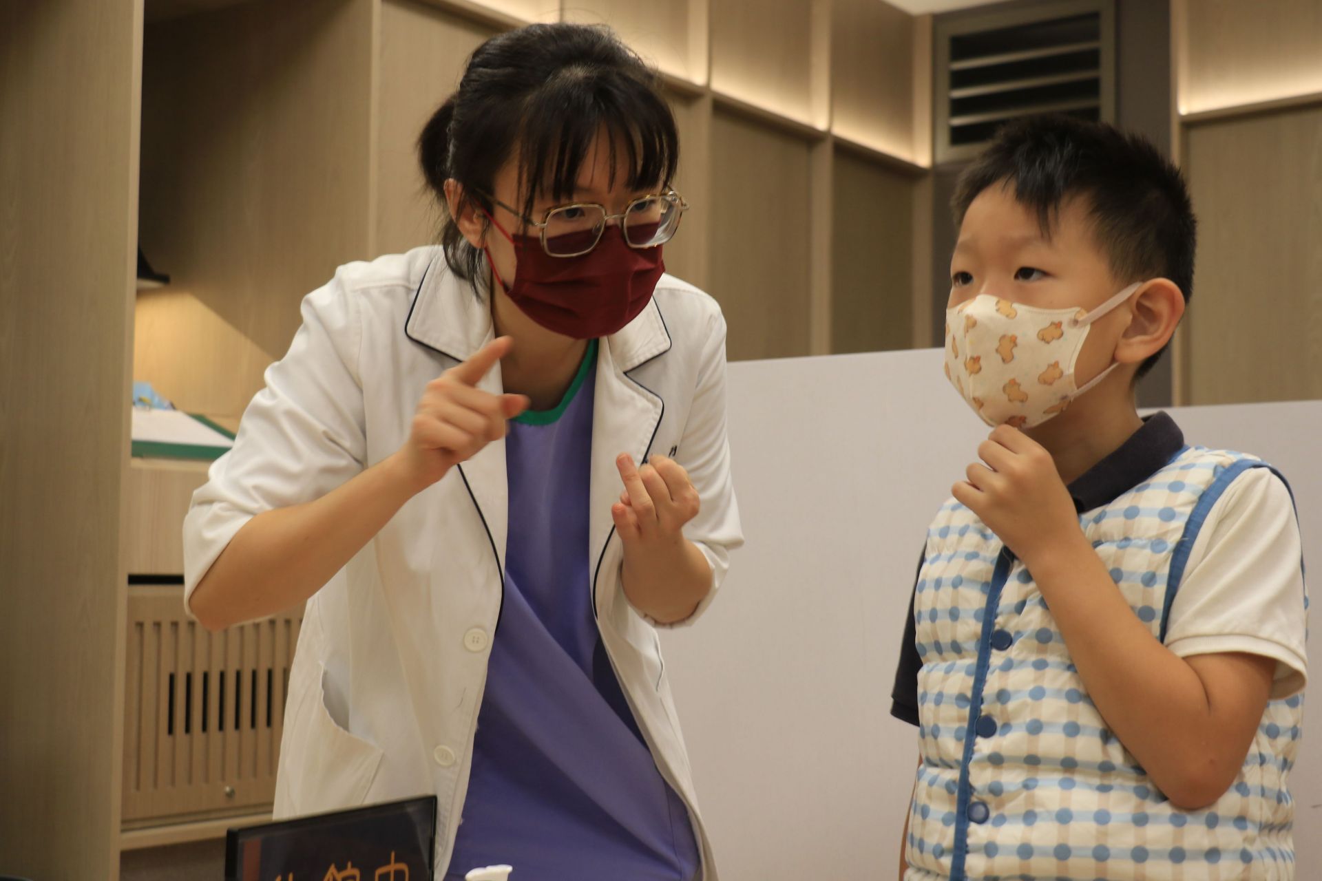 內視鏡檢查室同仁胡淑芬(左)將孩子帶至醫院圖書館托育前,貼心叮嚀孩子要聽話、配合志工照顧。