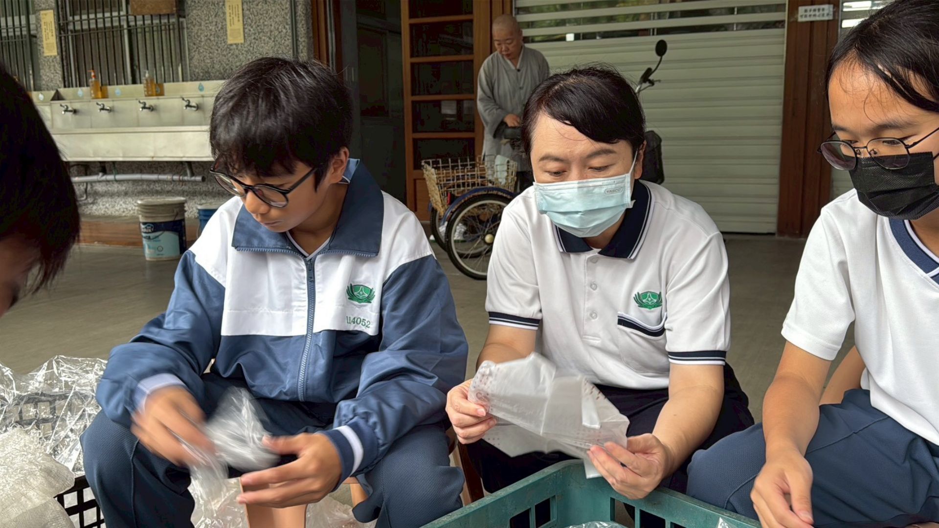 廖逸貞校長帶著學生一起整理回收的塑膠袋。
