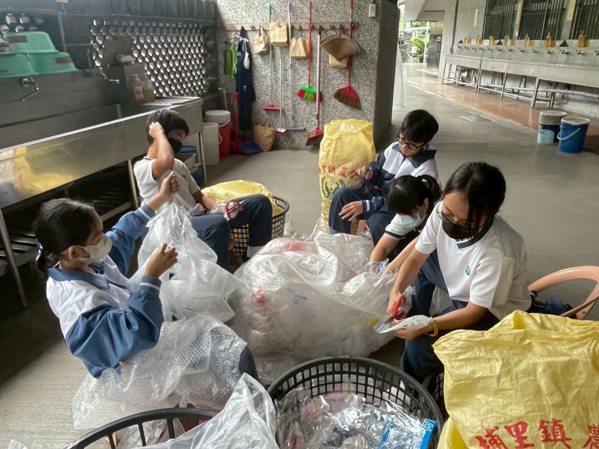 廖逸貞校長帶著學生一起整理回收的塑膠袋。
