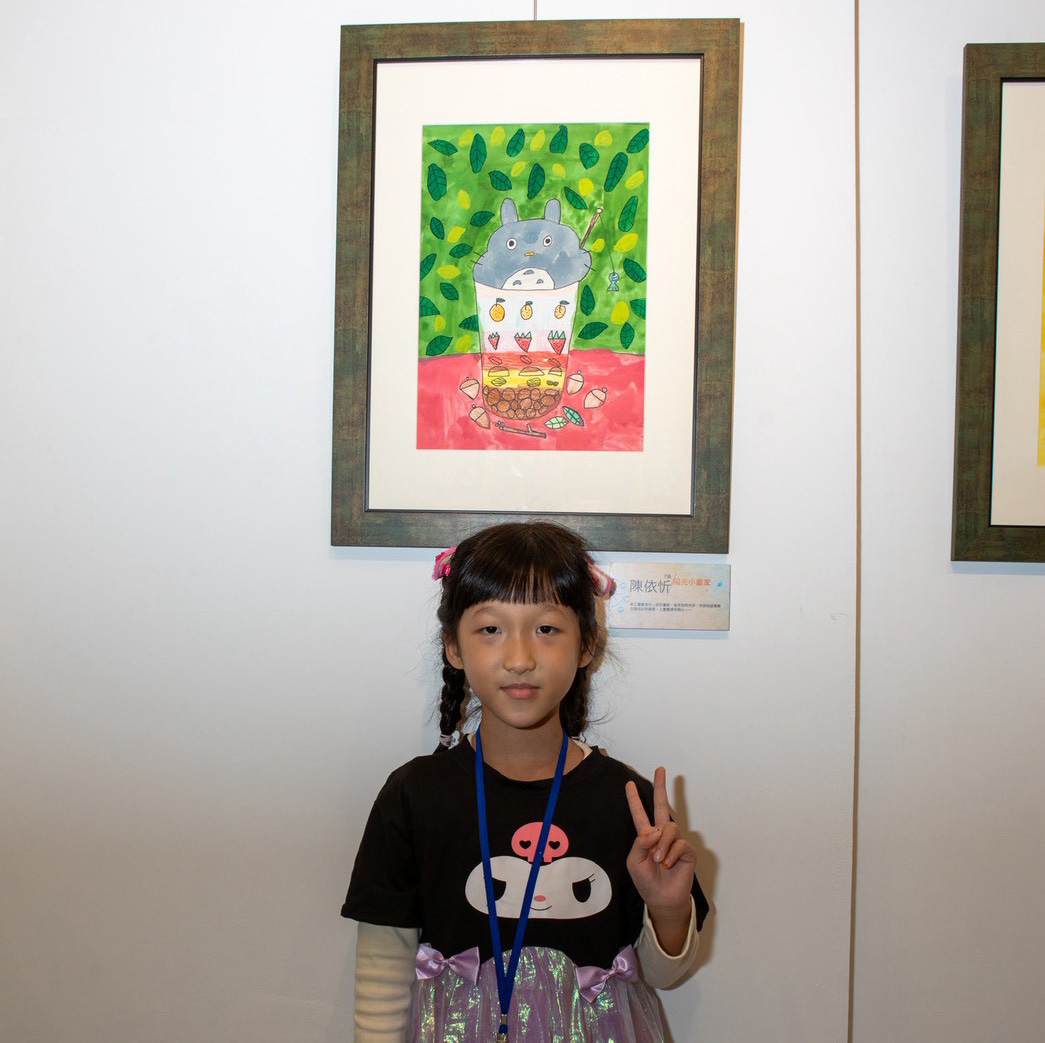忻忻開心地與自己的作品合影
