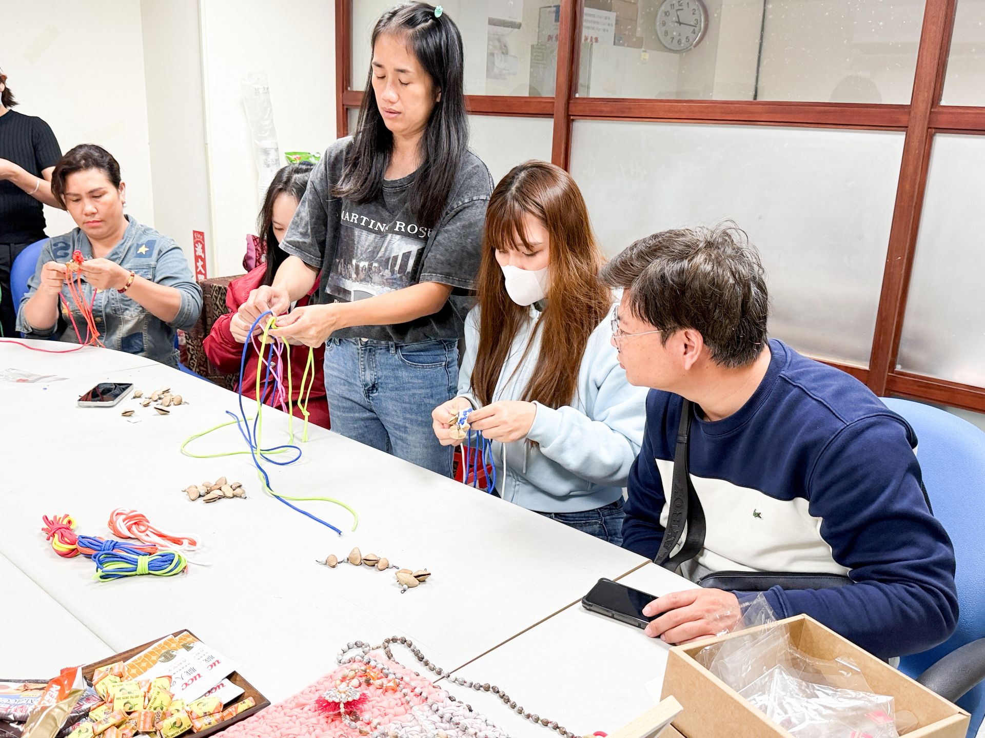張老師指導新住民及家屬編織夾竹桃手環。