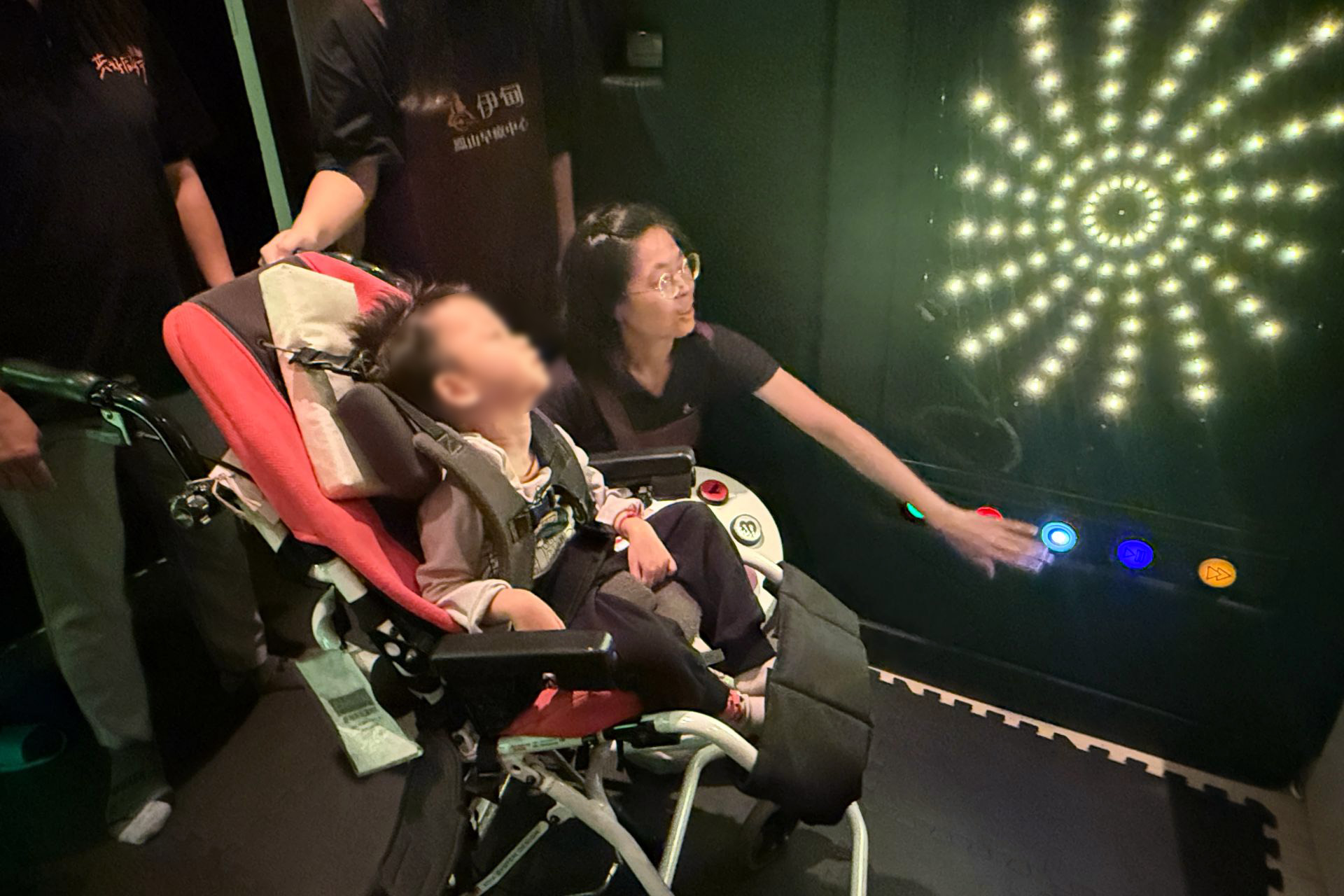 老師操作花火感官牆設備，樂樂的目光被閃爍躍動的燈光吸引，讓他的注意力能集中。