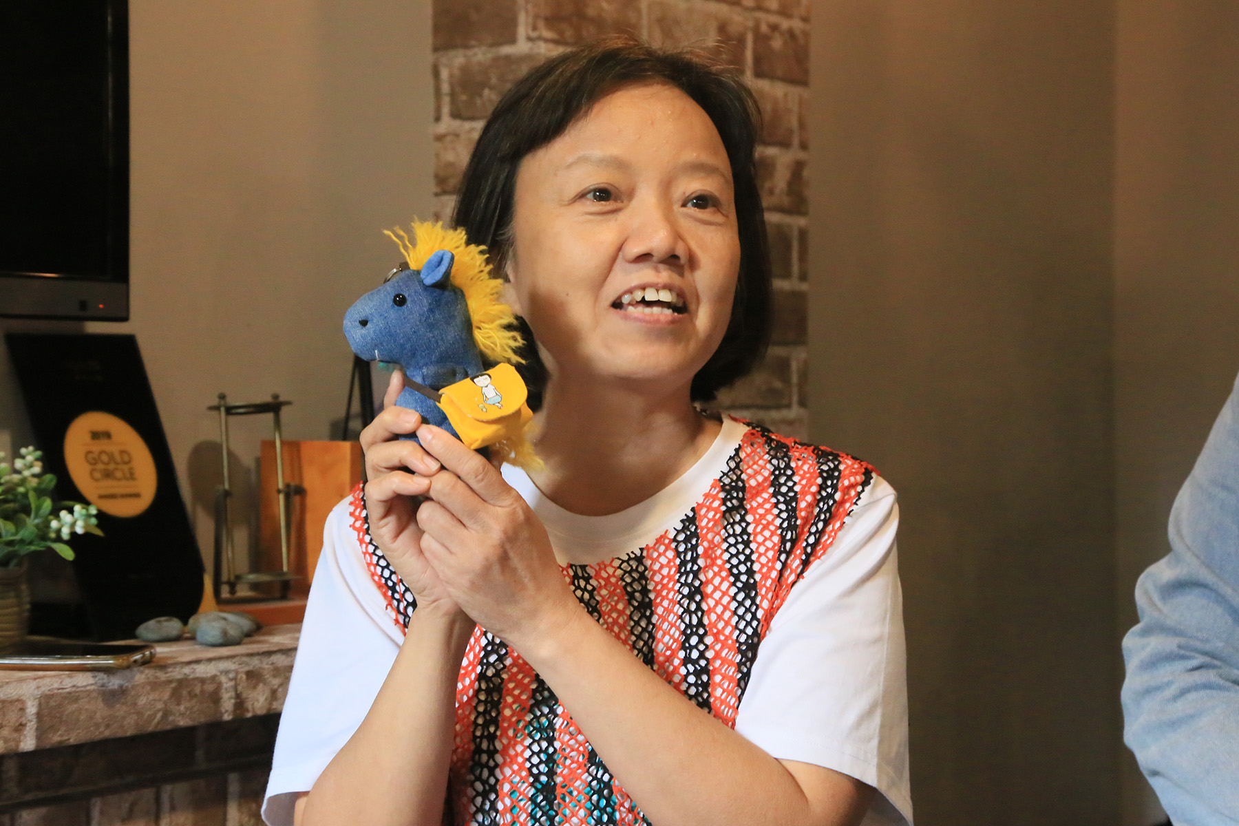 布藝師媽媽介紹自己設計的布娃吊飾時顯得自信滿滿