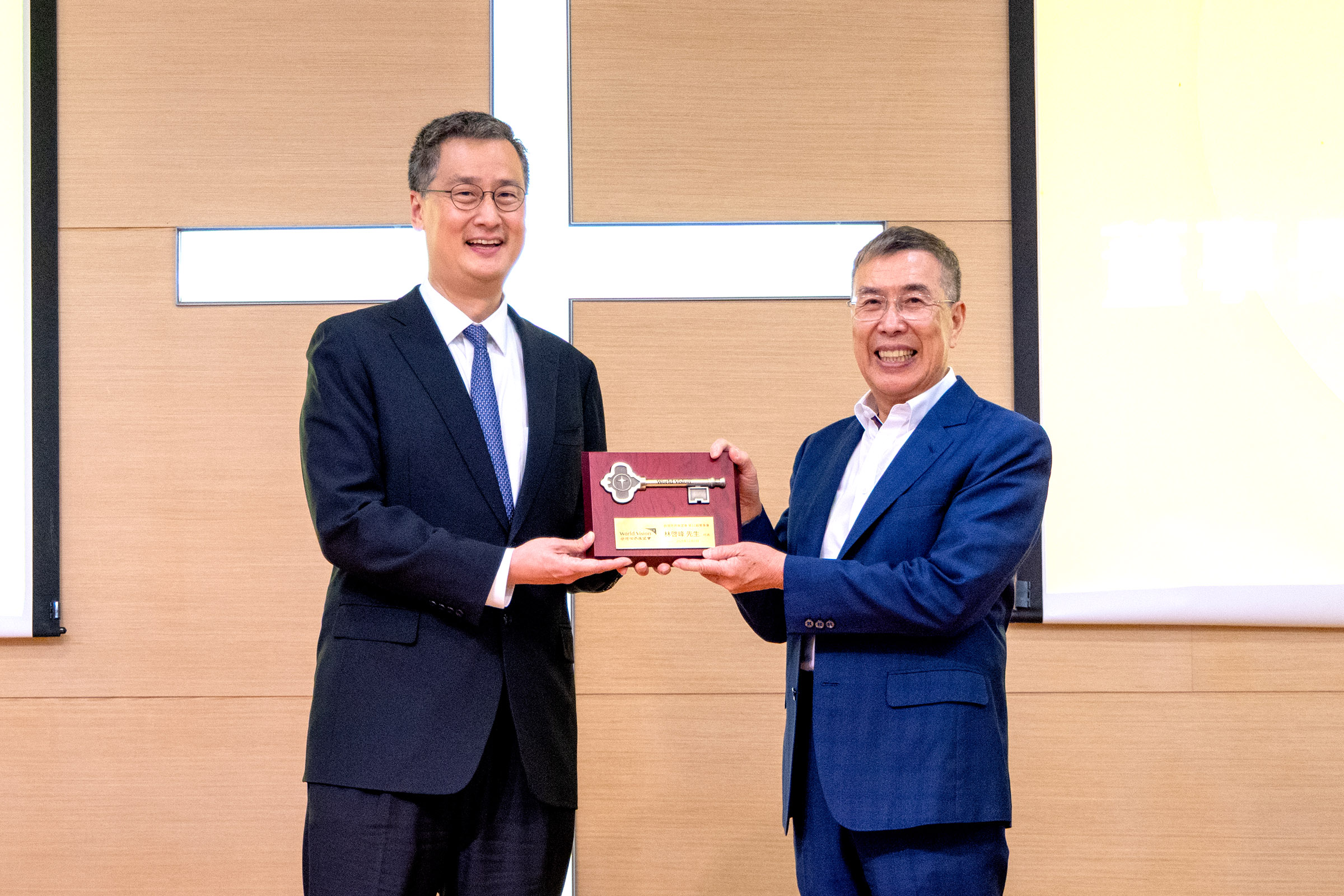 第20屆董事長丁廣欽(左)將象徵服務使命的信物「展望未來鑰匙」交棒第21屆董事代表林啓峰(右)，要繼續為最有需要的兒童與家庭打開盼望的門。