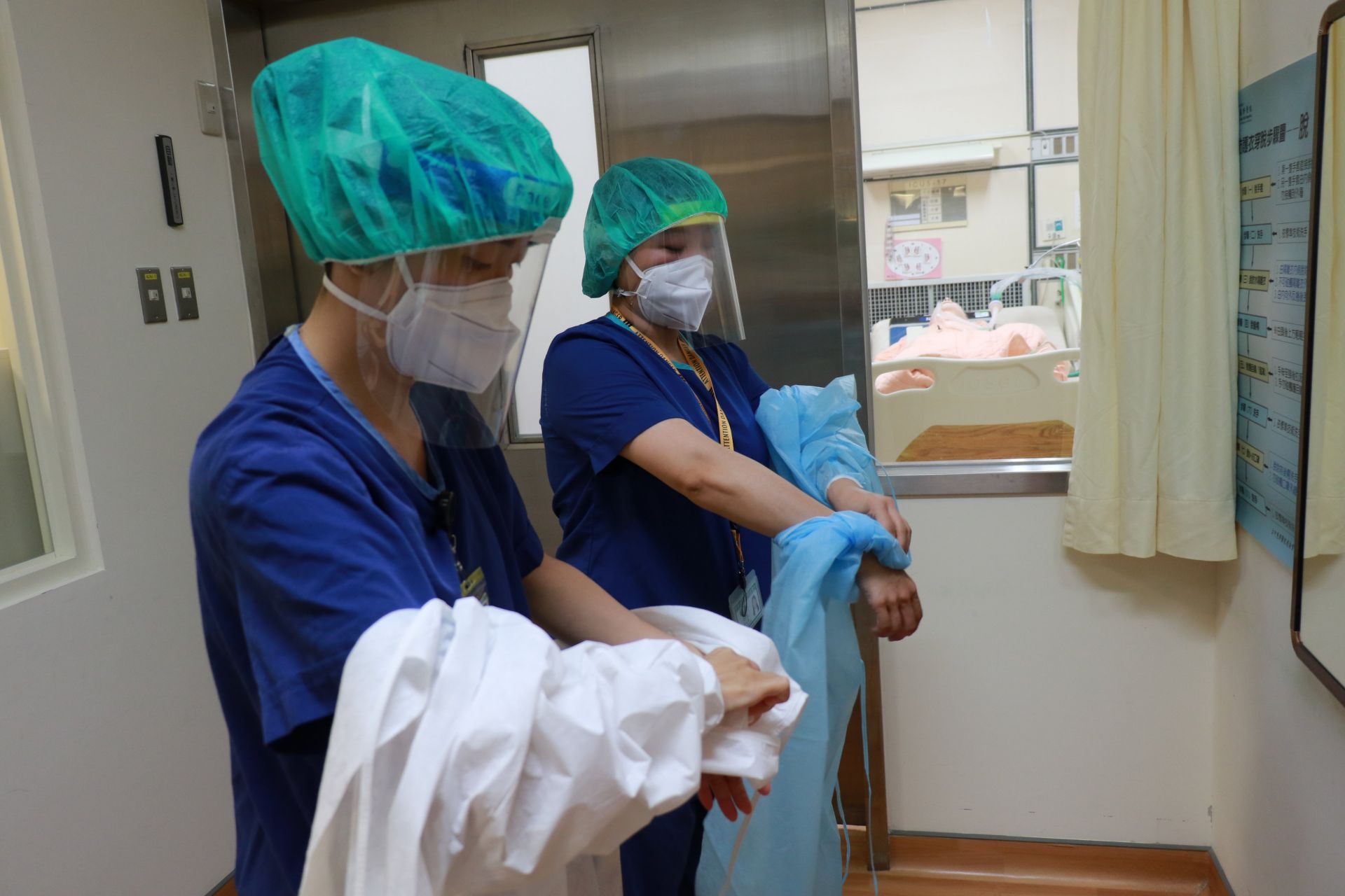 護理人員在負壓加護病房結束照護後，於前室依程序卸下防護裝備並完成手部消毒。