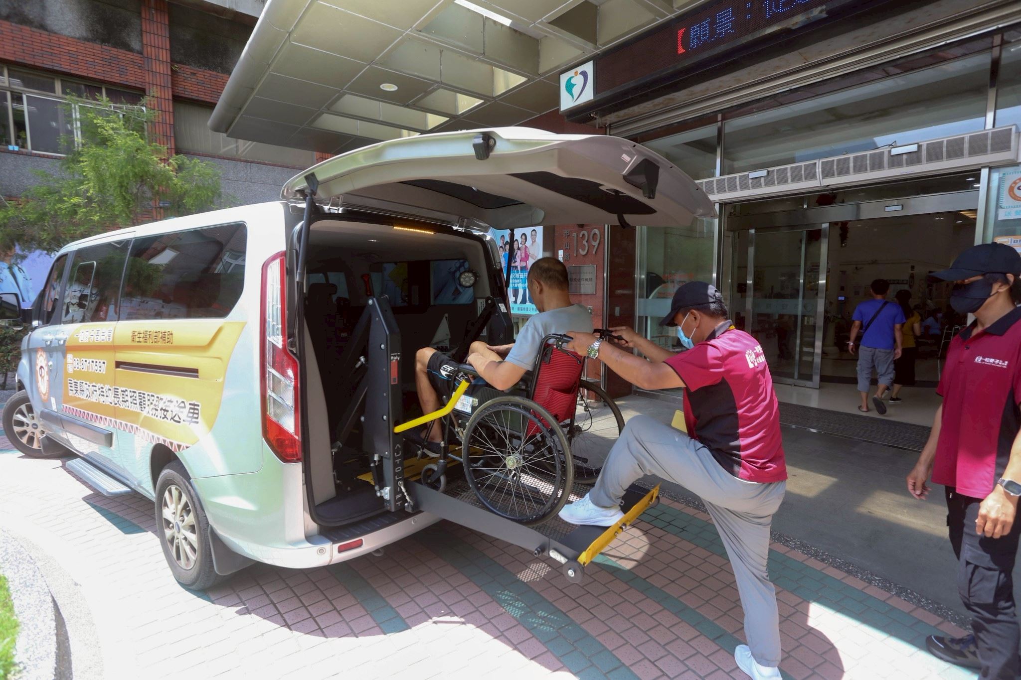 長照交通車於醫院外協助輪椅長者安全就醫