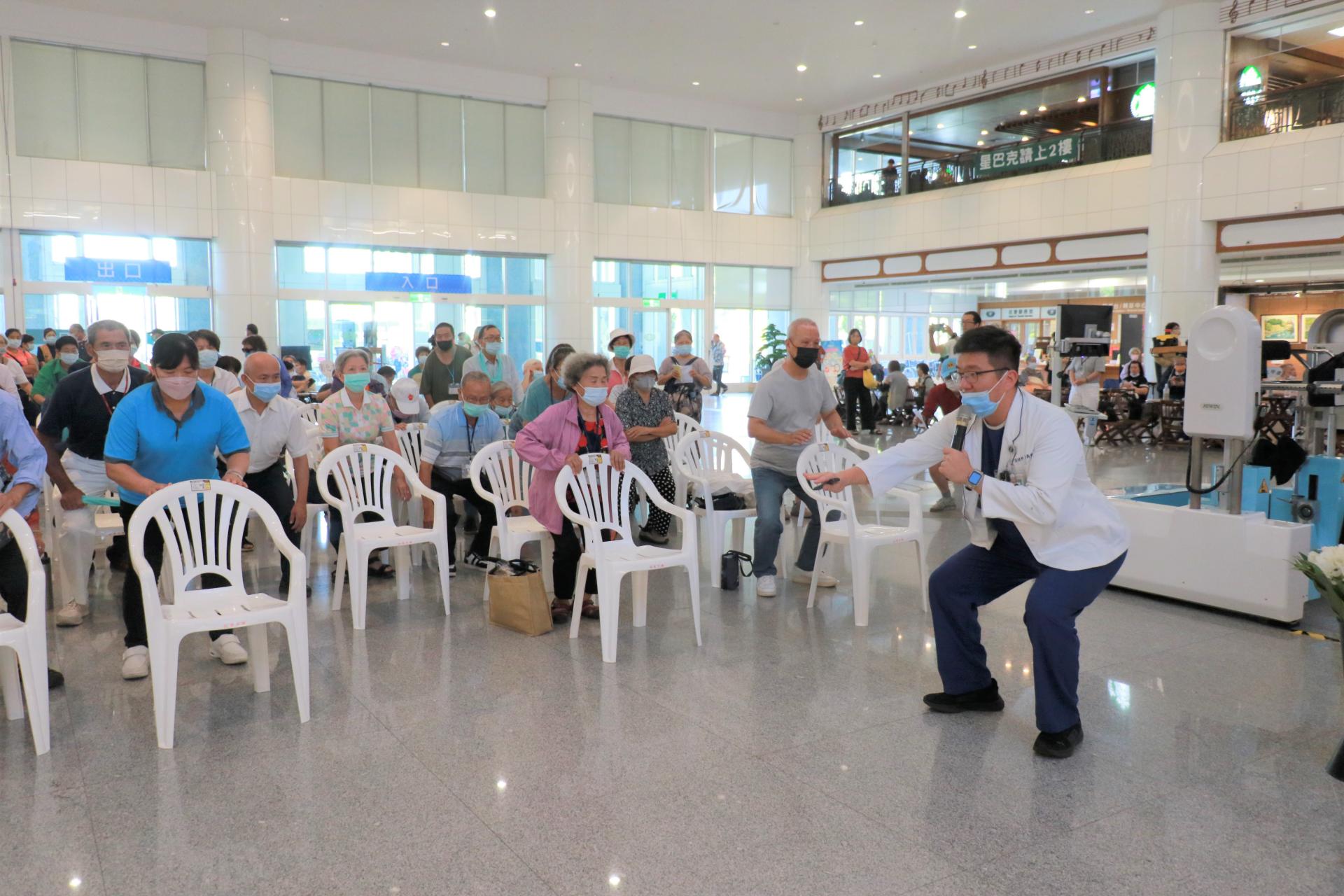 物理治療師陳義豪(右)現場示範深蹲動作。