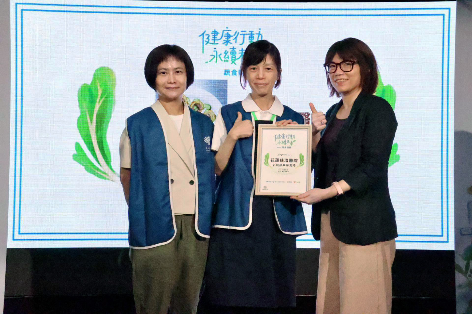 花蓮慈院作品「彩蔬蘋果芋泥捲」獲得健康行動低碳蔬食組「最佳創意獎」肯定。由營養科主任劉詩玉（左）和廚師莊淑倩（中）代表受獎。