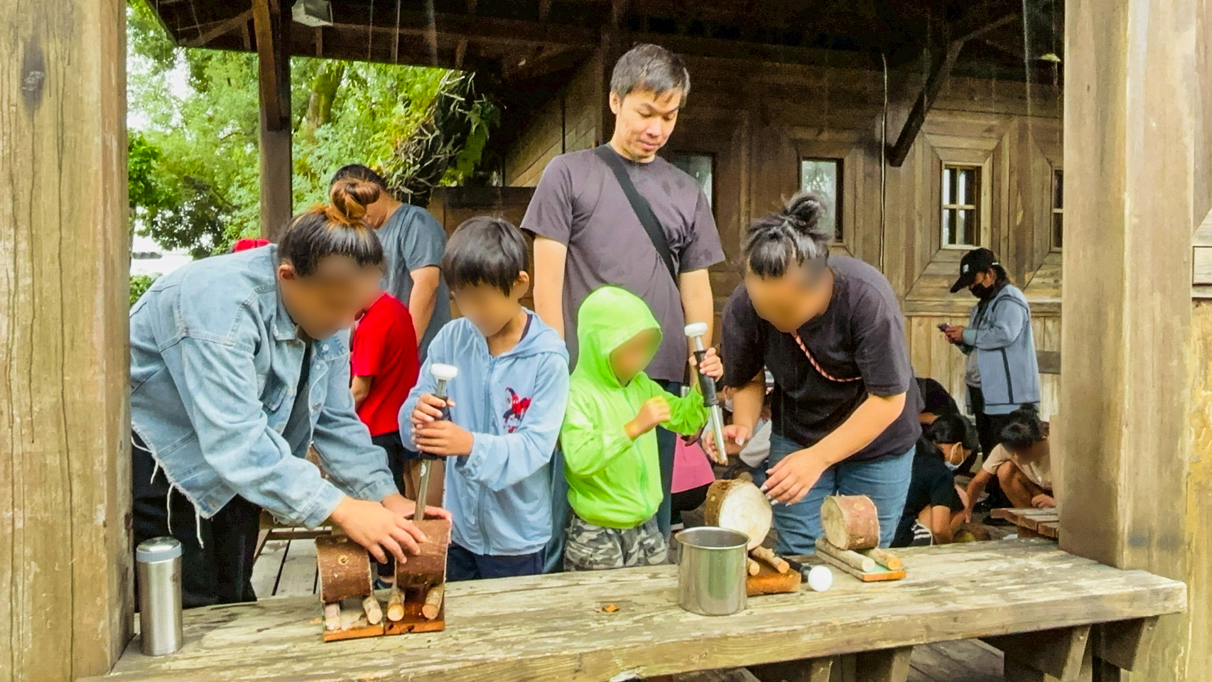 親子齊心協力將木耳菌胞灌入段木中