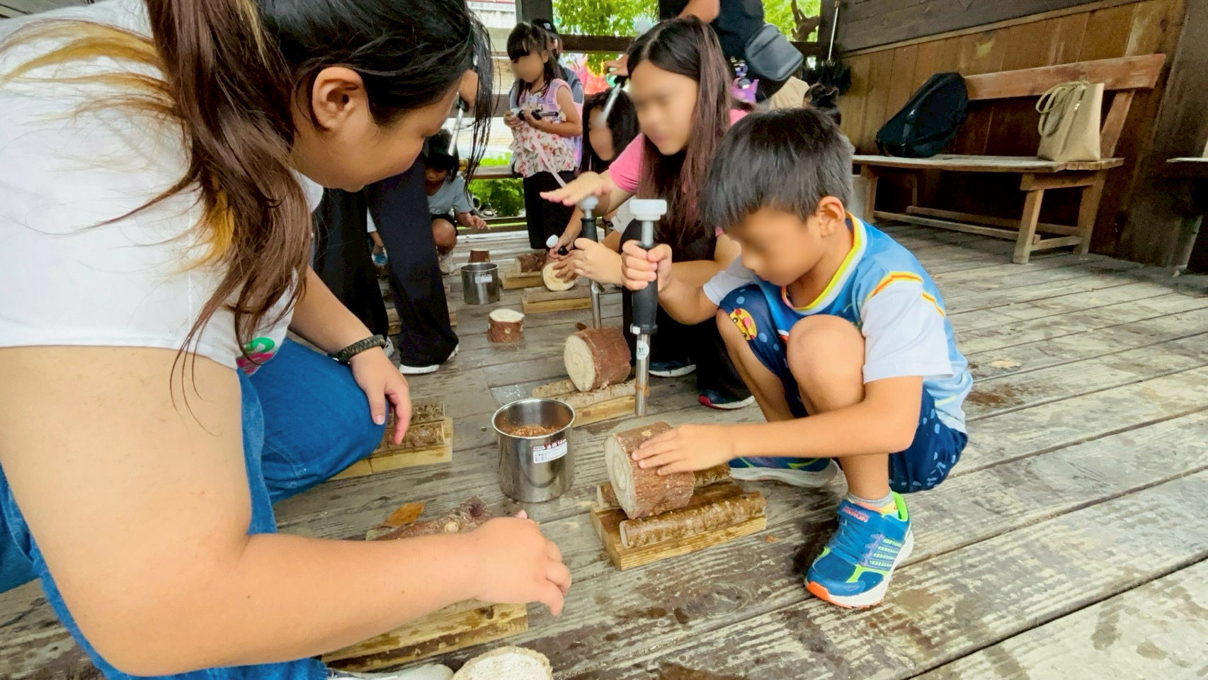 親子齊心協力將木耳菌胞灌入段木中