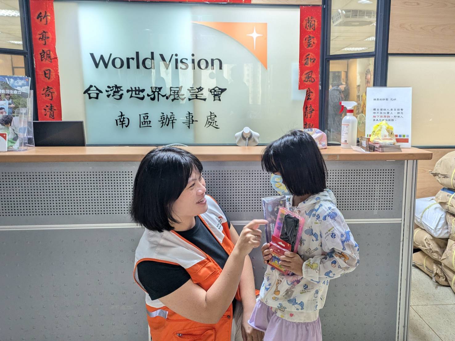 社工員親自將九乘九文具專家捐贈的文具包送到小江妹妹手中