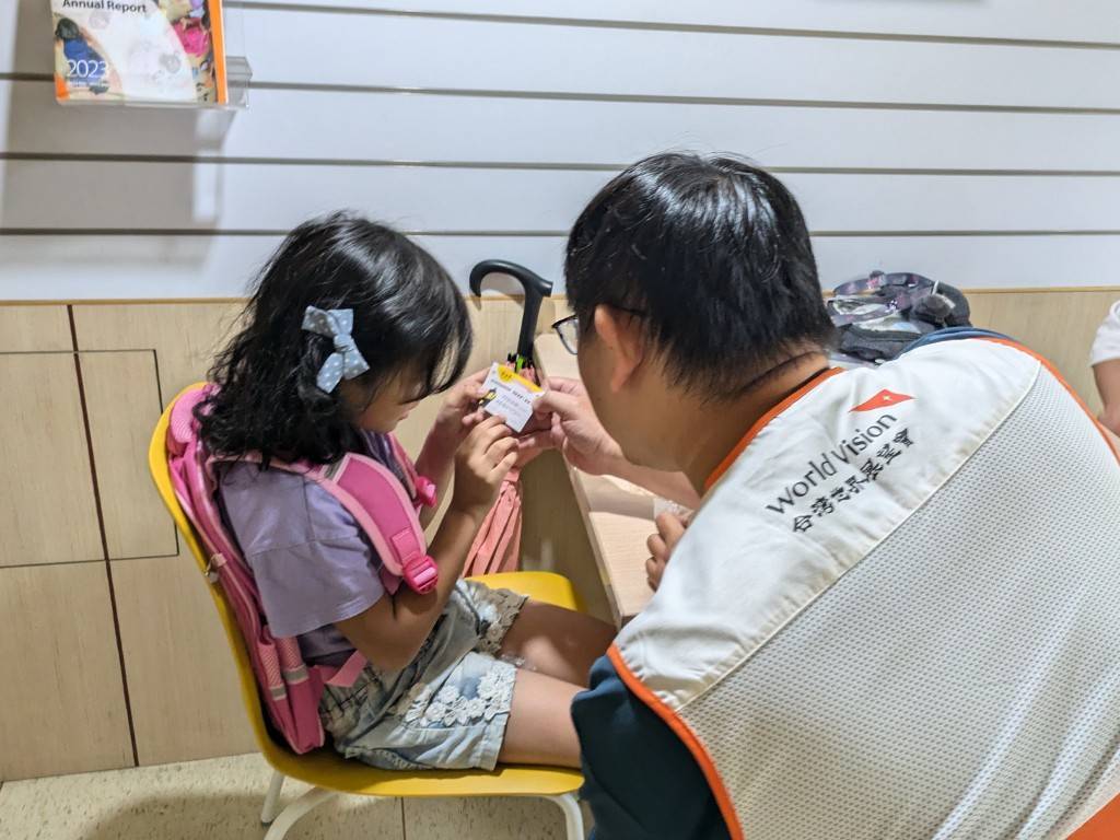孩子專心閱讀金石堂的愛心卡片。